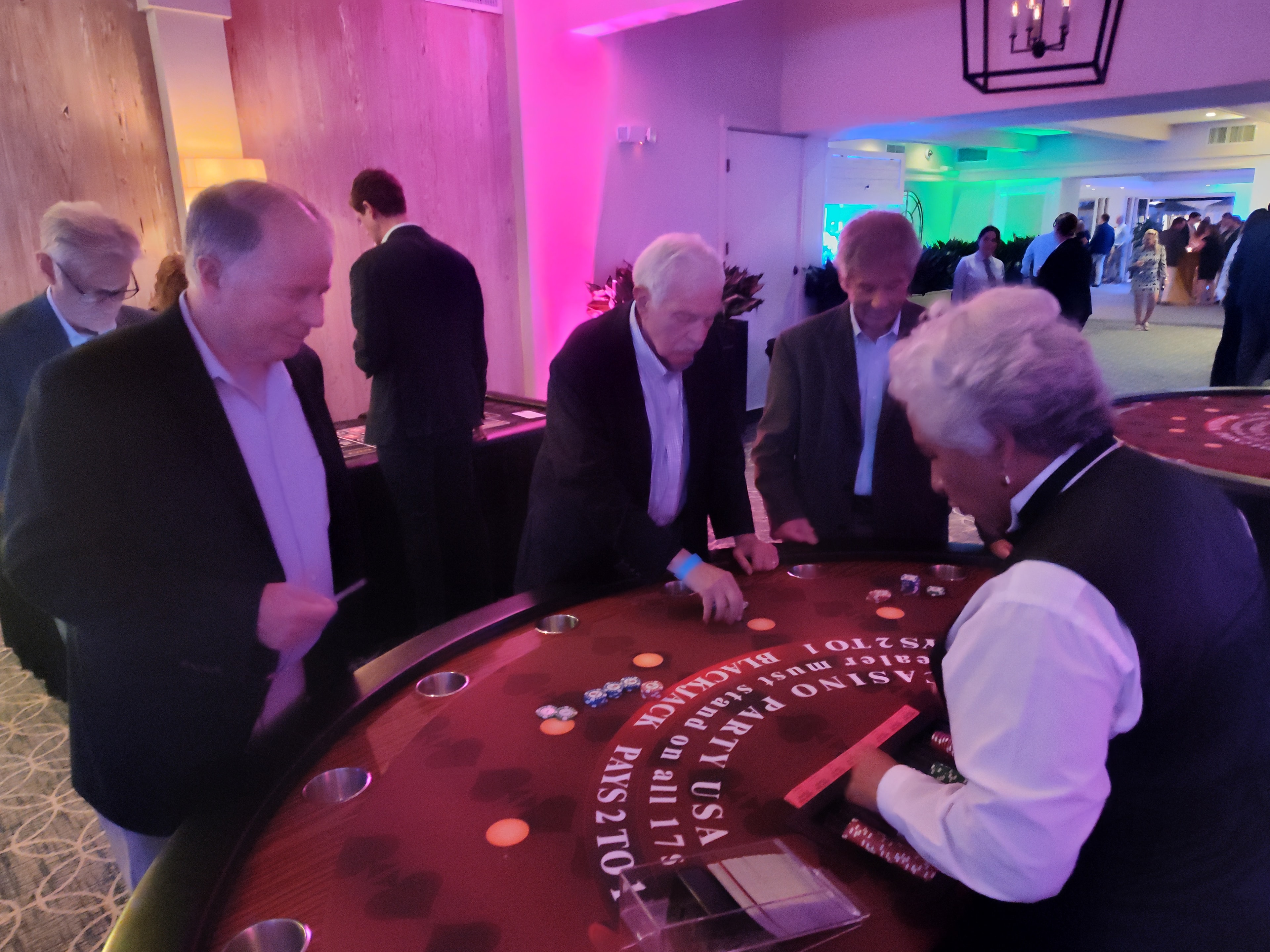 Guests and dealer at a blackjack table under colorful uplighting at a Billings Casino Party USA event