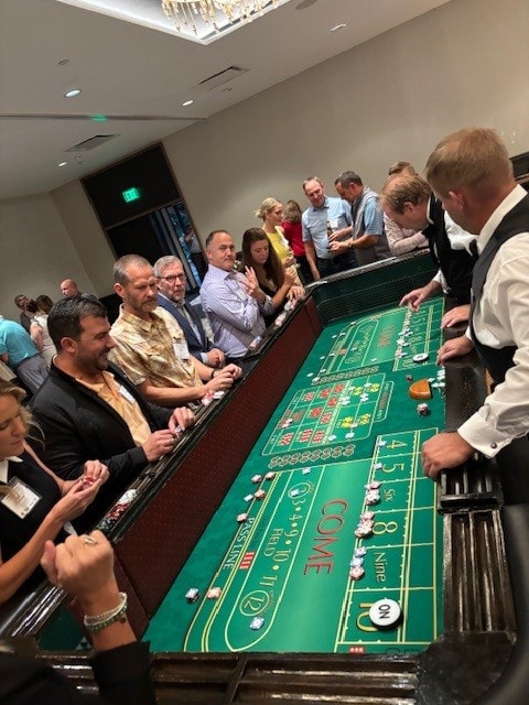 Guests crowded around a craps table at a Casino Party USA corporate event