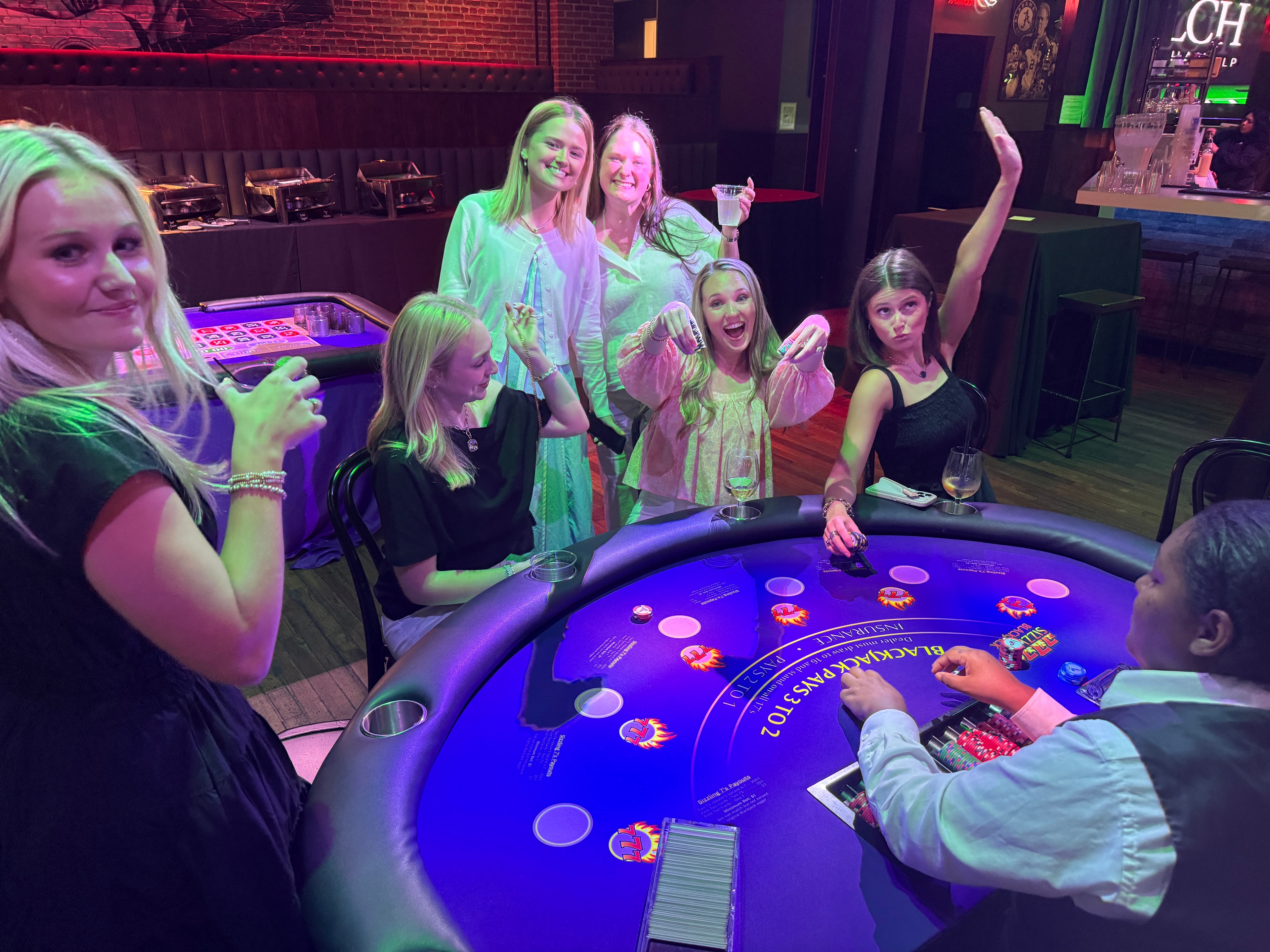 Guests crowded around a roulette table at a Casino Party USA outdoor event