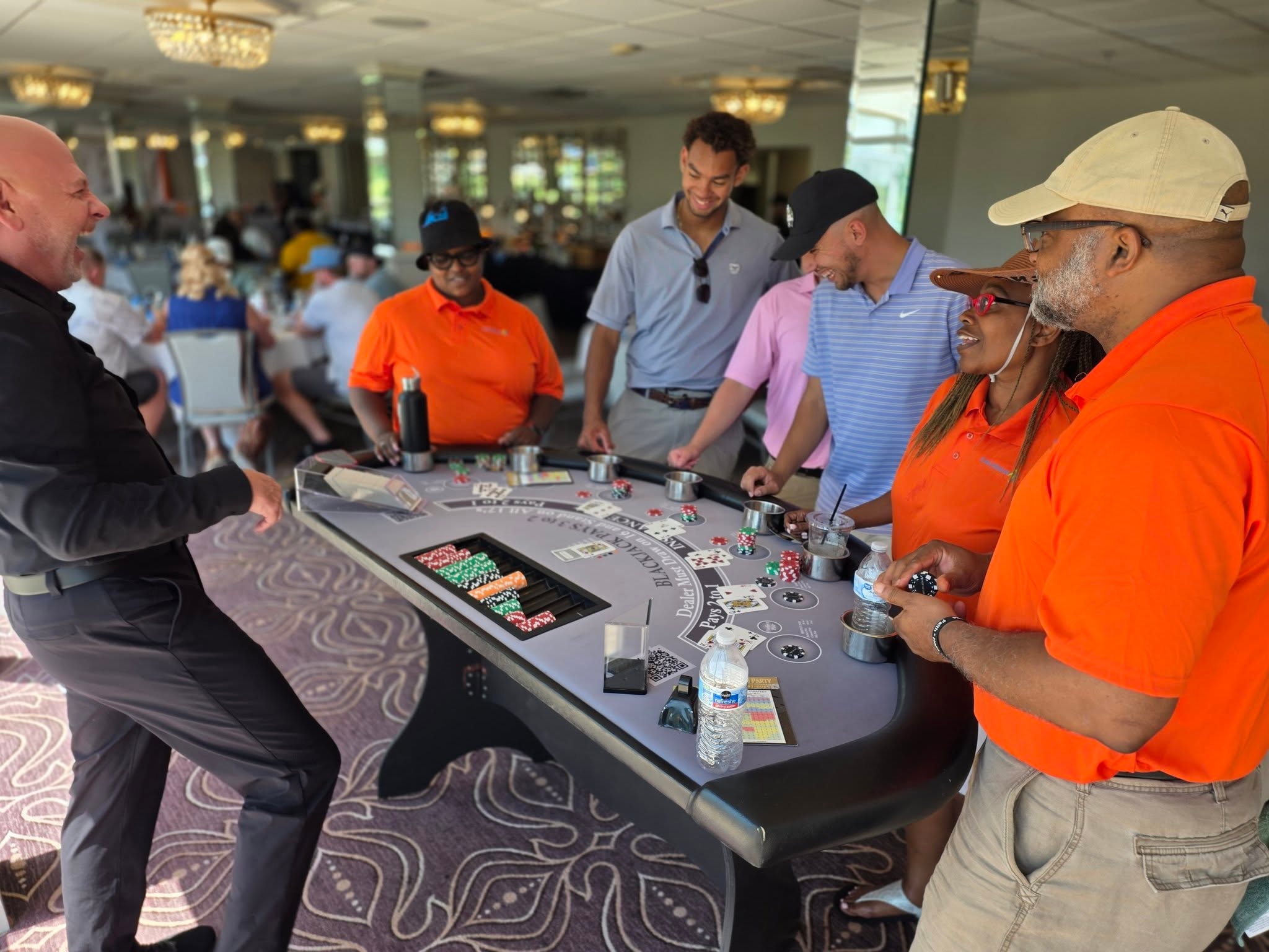 Guests playing Texas Hold'em on a branded Casino Party USA poker table at the CCIG corporate event