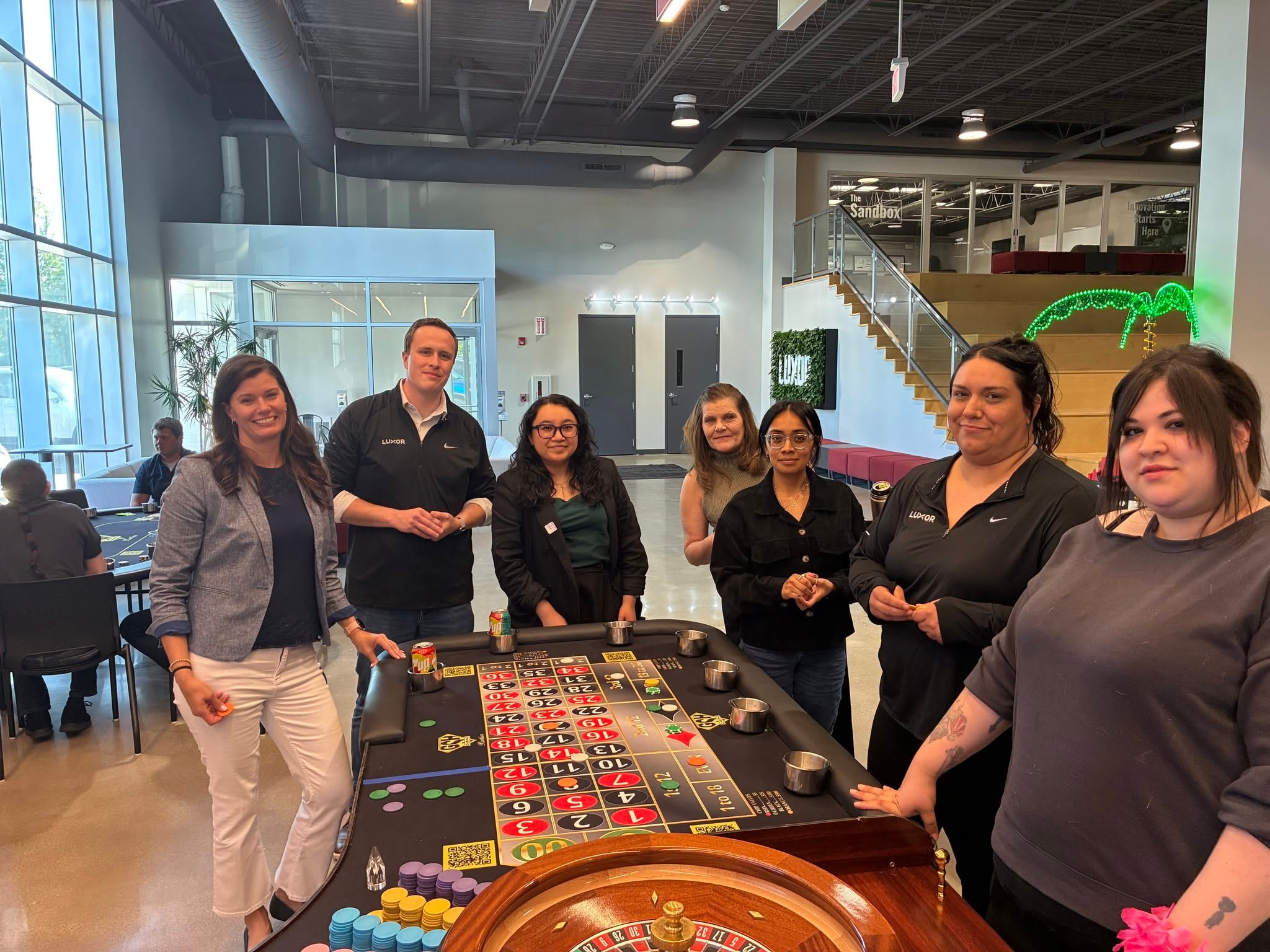 Group of guests smiling around a roulette table at a Chicago Casino Party USA corporate event