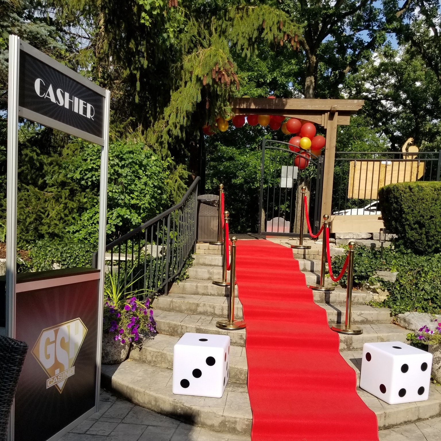 Outdoor red carpet casino entrance with GSH Casino cashier stand and balloon arch at a Chicago Casino Party USA event
