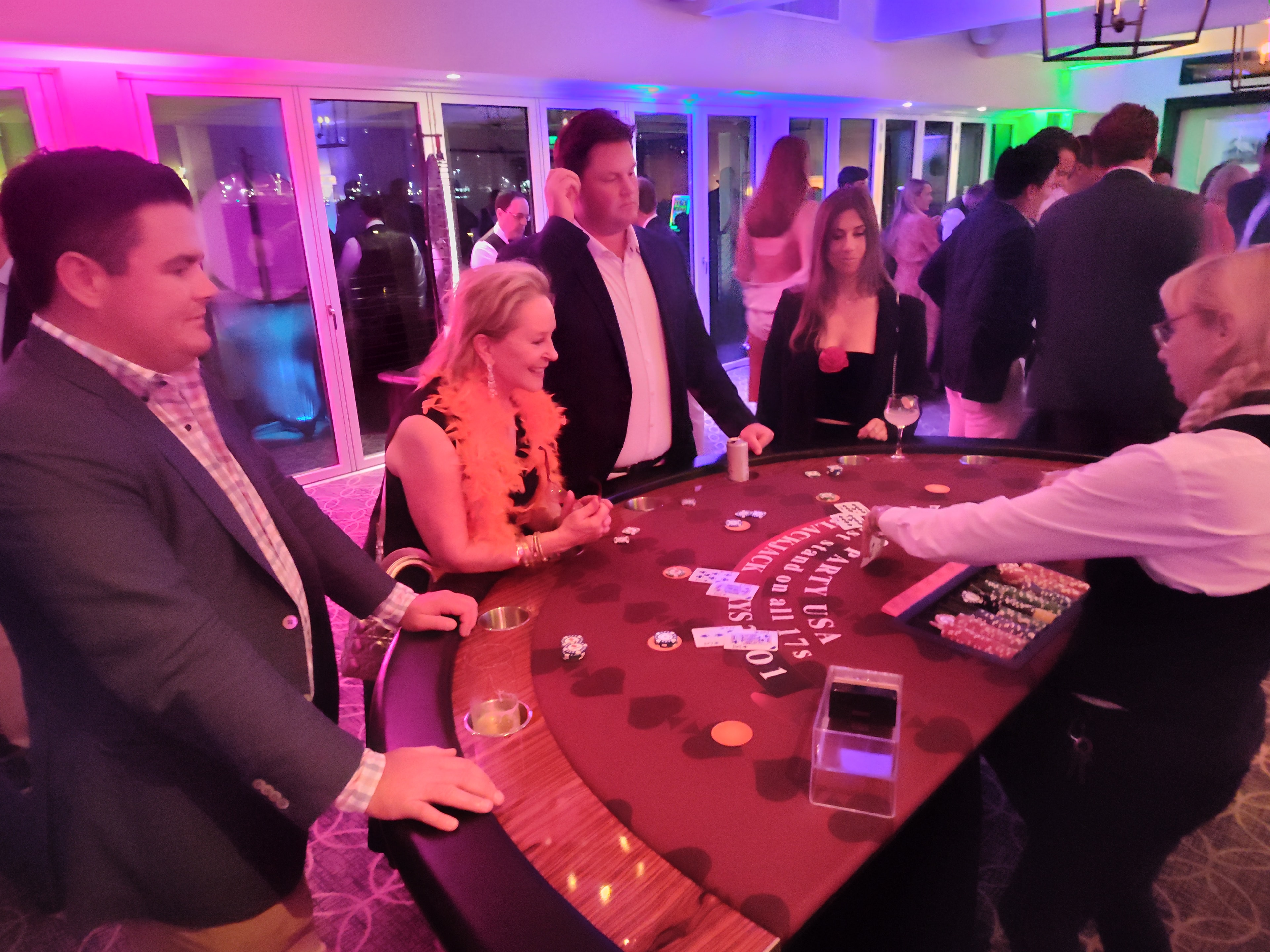 Guests playing blackjack with a feather boa at a Colorado Springs Casino Party USA event