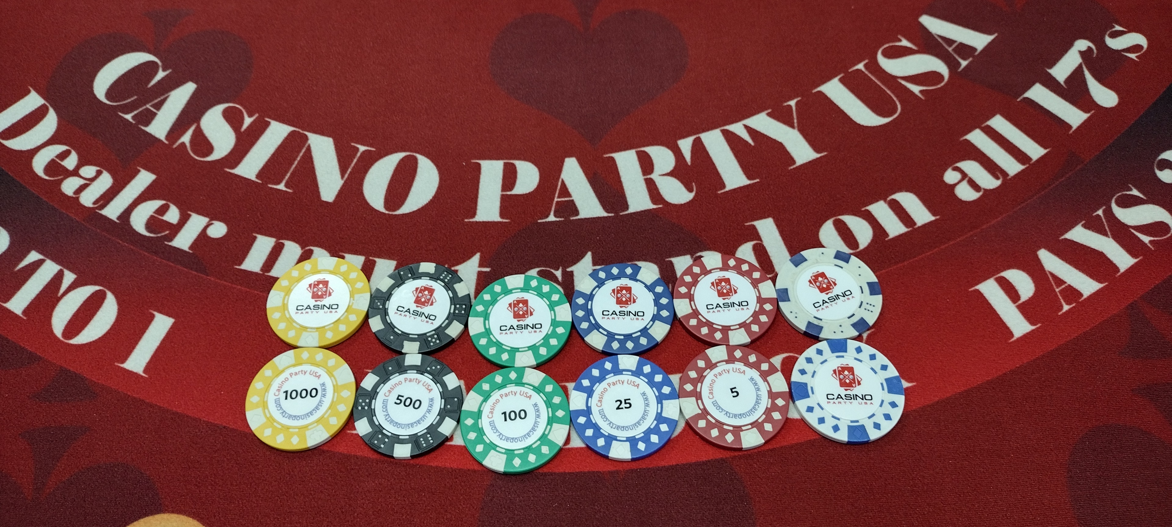 Casino Party USA custom printed casino chips in six denominations on red felt blackjack table — personalized logo chips