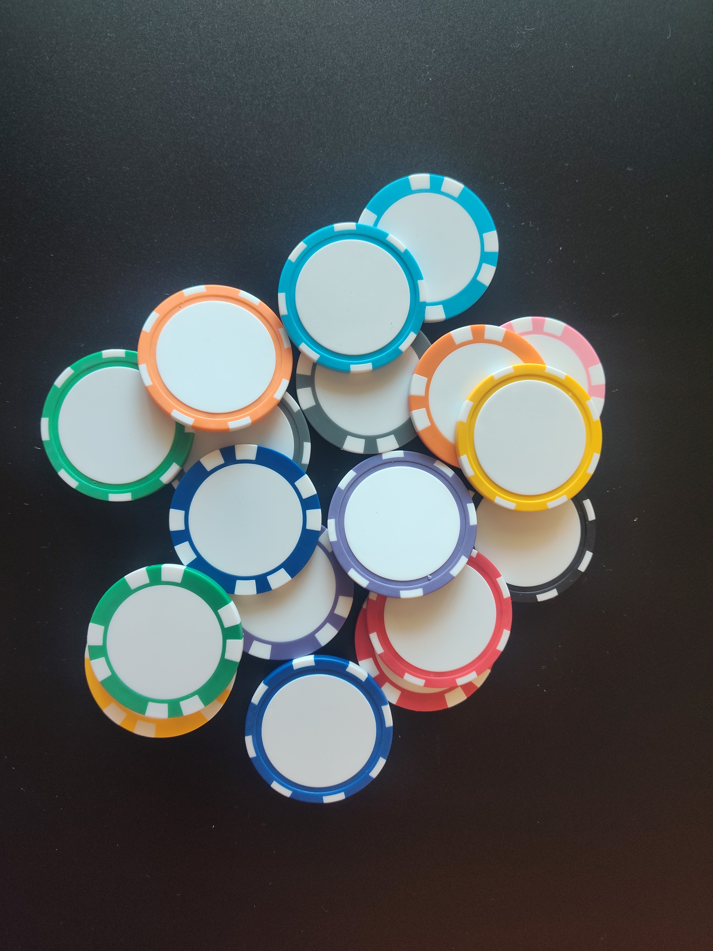 Colorful custom casino chips in blue, orange, pink, yellow, green and red with diamond-pattern borders — personalized poker chips for events