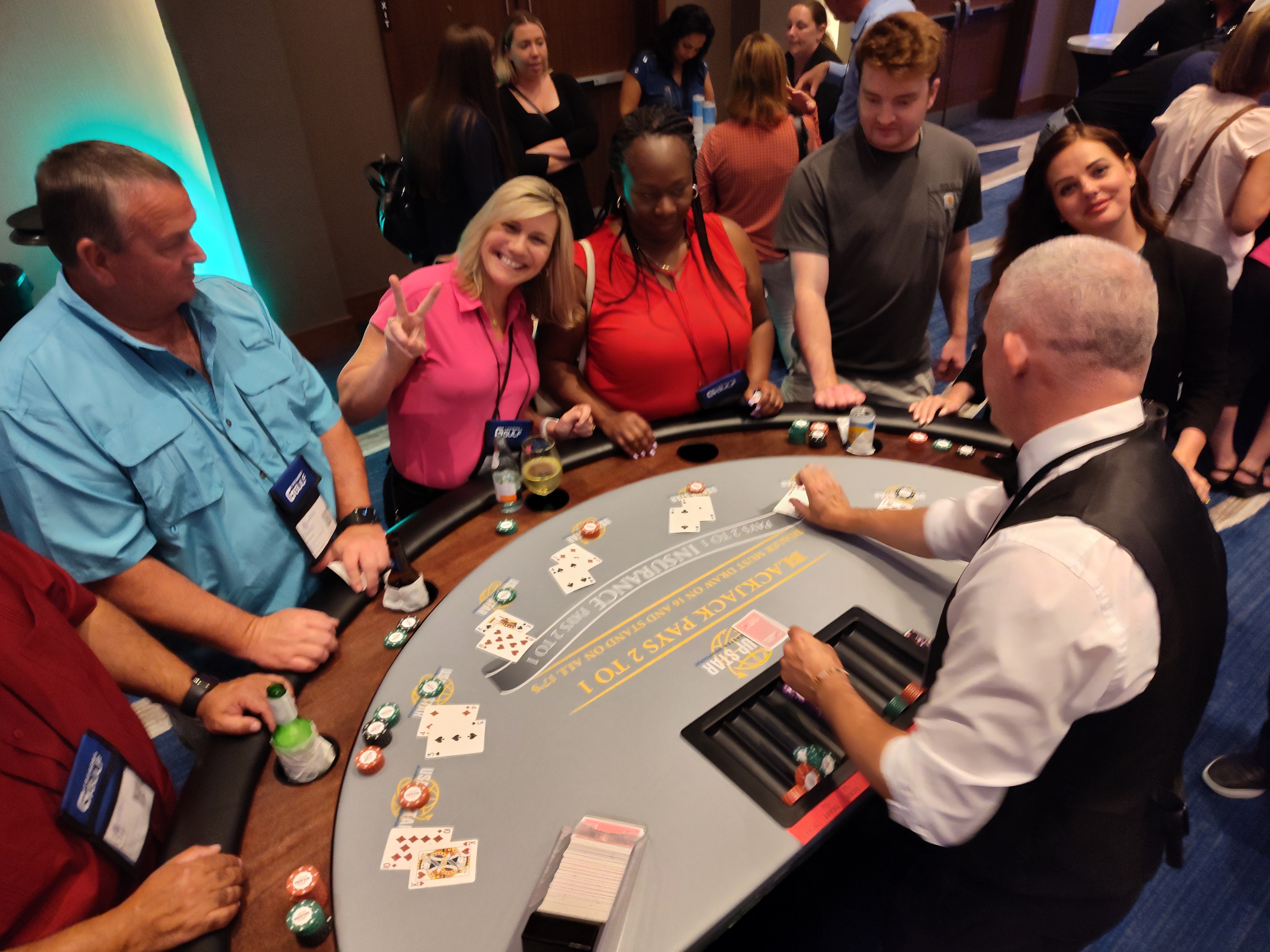 Guests playing blackjack at custom branded casino table felt at corporate event — Casino Party USA