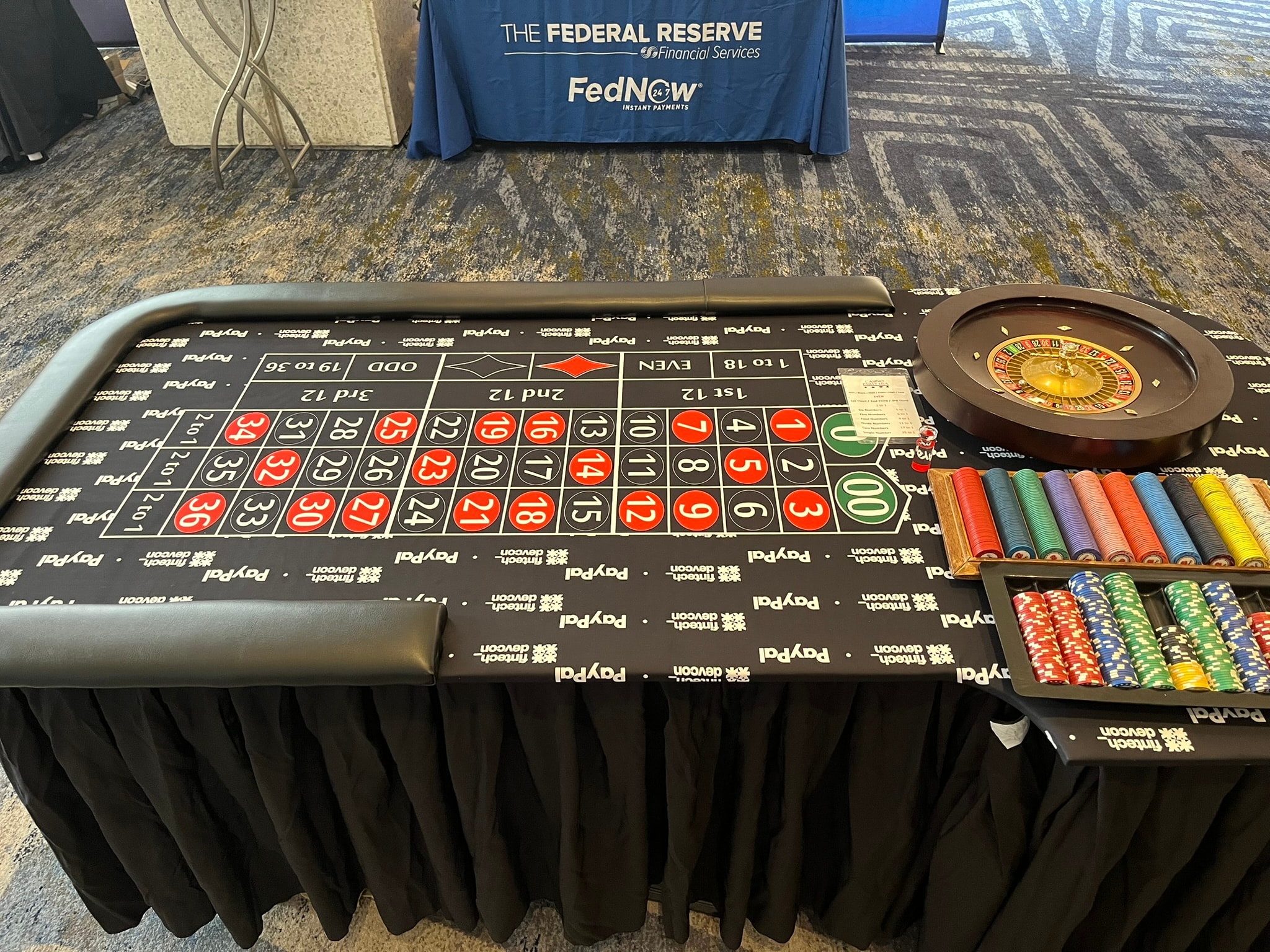 Custom branded roulette table felt with corporate sponsor logos at casino party event