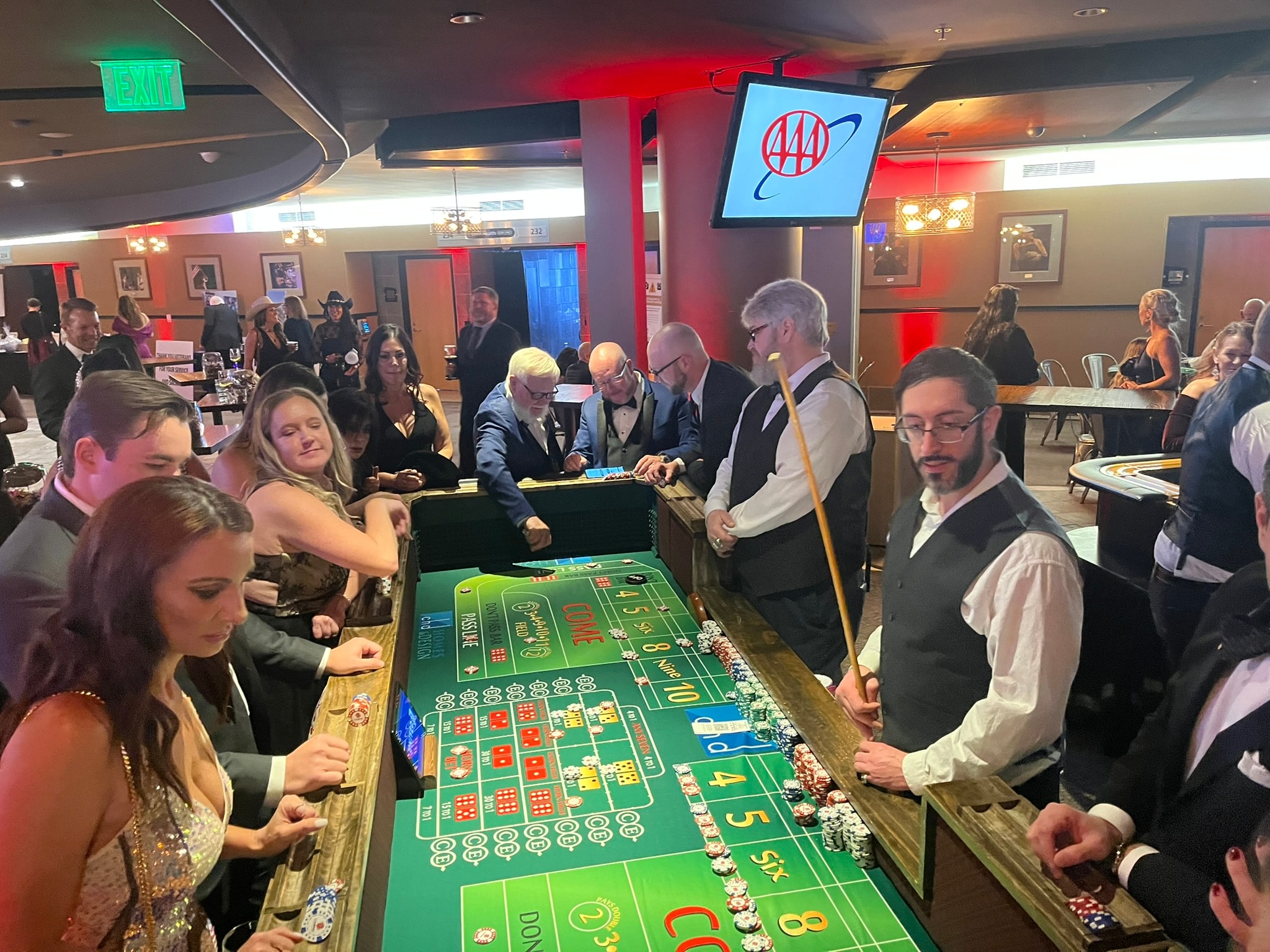 Guests playing craps at custom branded casino table felt at AAA corporate casino party event