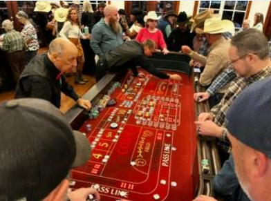 Guests crowded around a red craps table at a Dallas Casino Party USA event