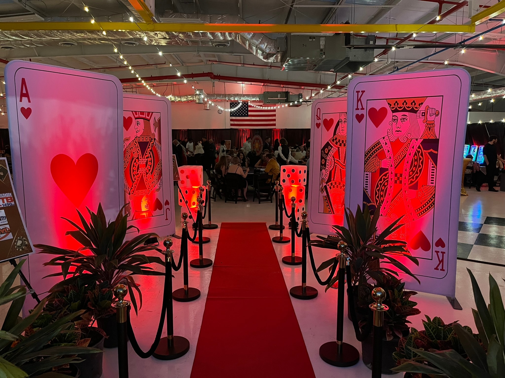 Casino party decorations — giant playing card entrance with red carpet