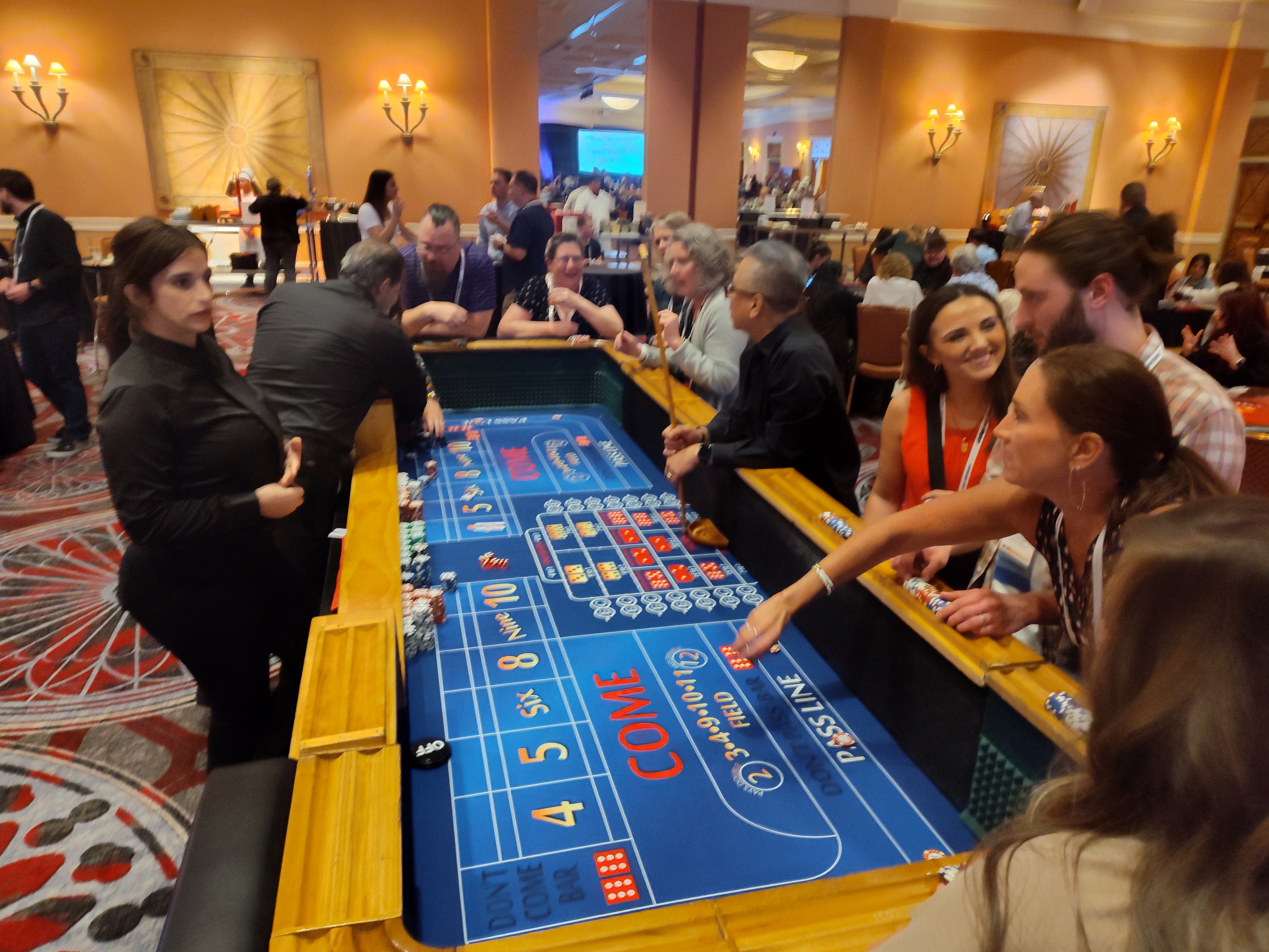 Guests crowded around a blue craps table at a Denver Casino Party USA event