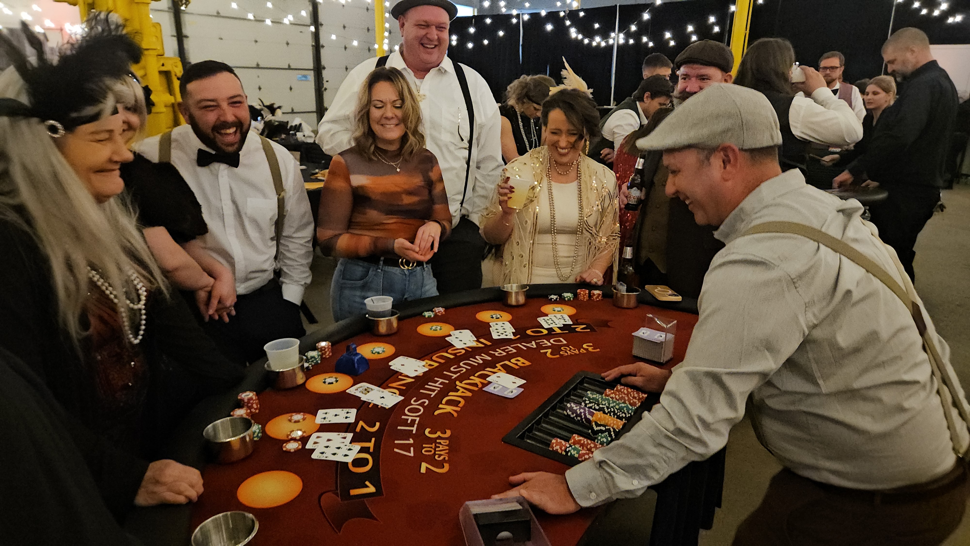Guests in Roaring 20s attire enjoying blackjack at a Des Moines themed casino party