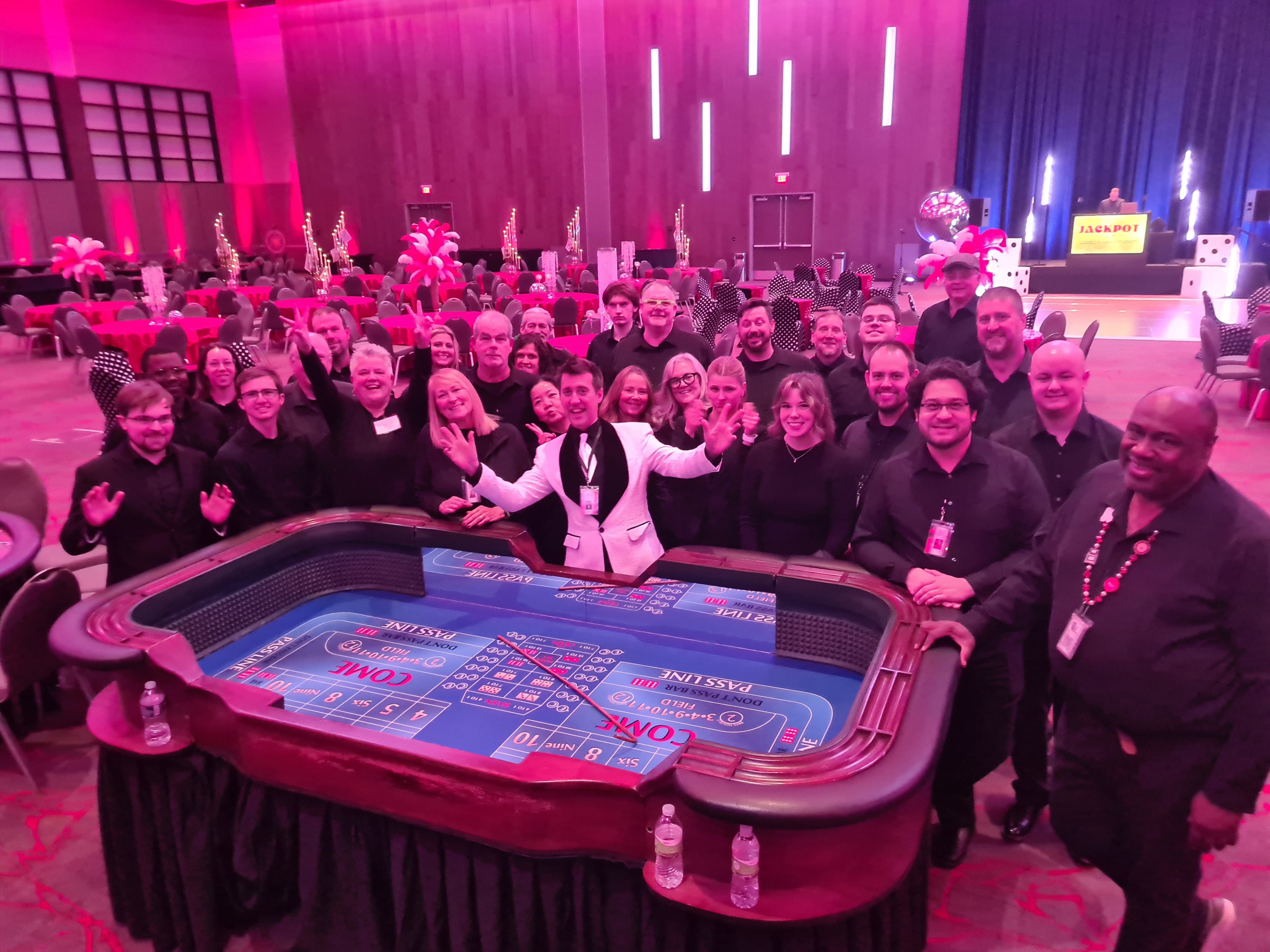 Large group of Casino Party USA staff and guests around a craps table at a Des Moines gala