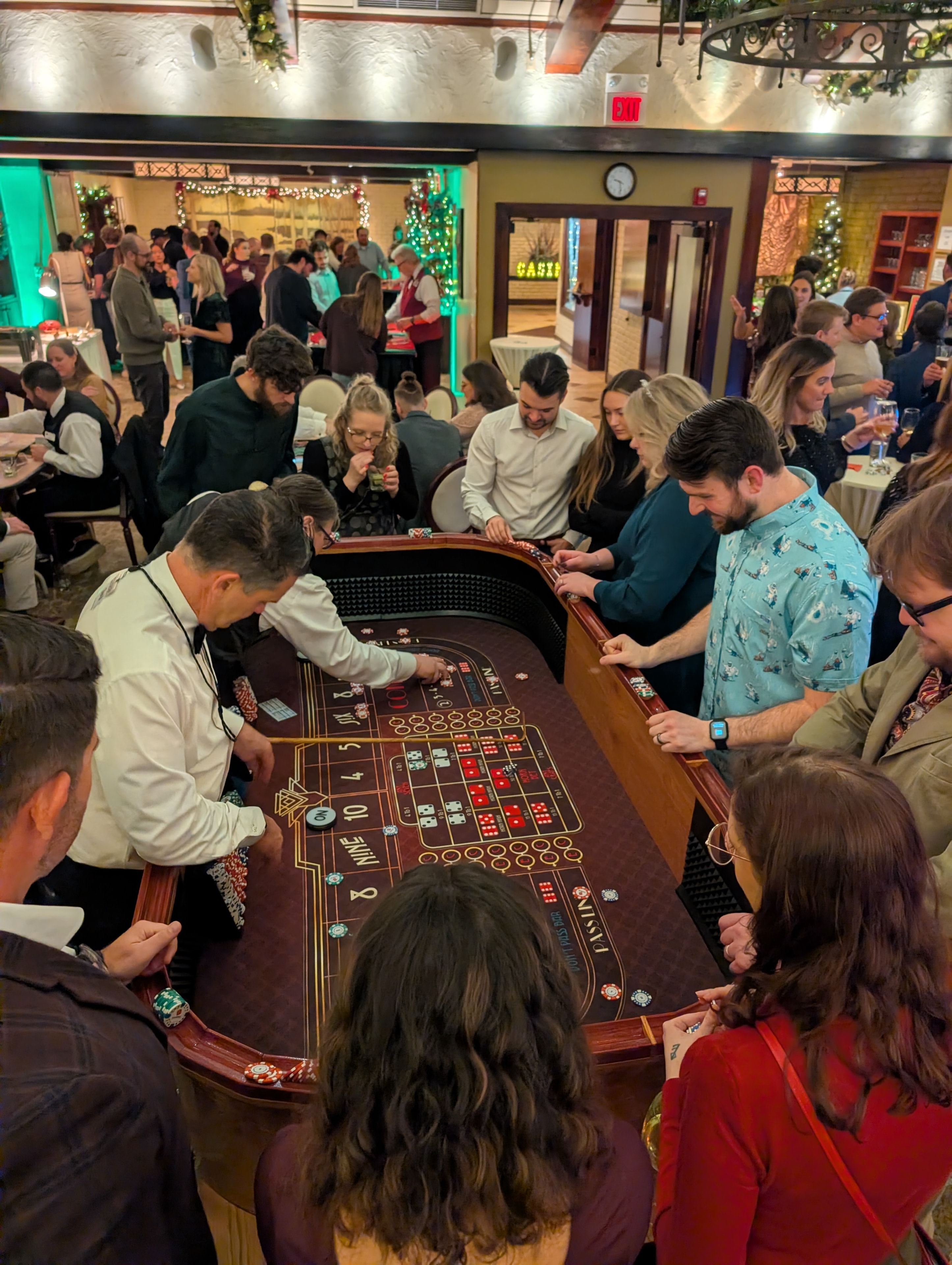 Packed craps table with dealer and large crowd at a Casino Party USA Detroit holiday event