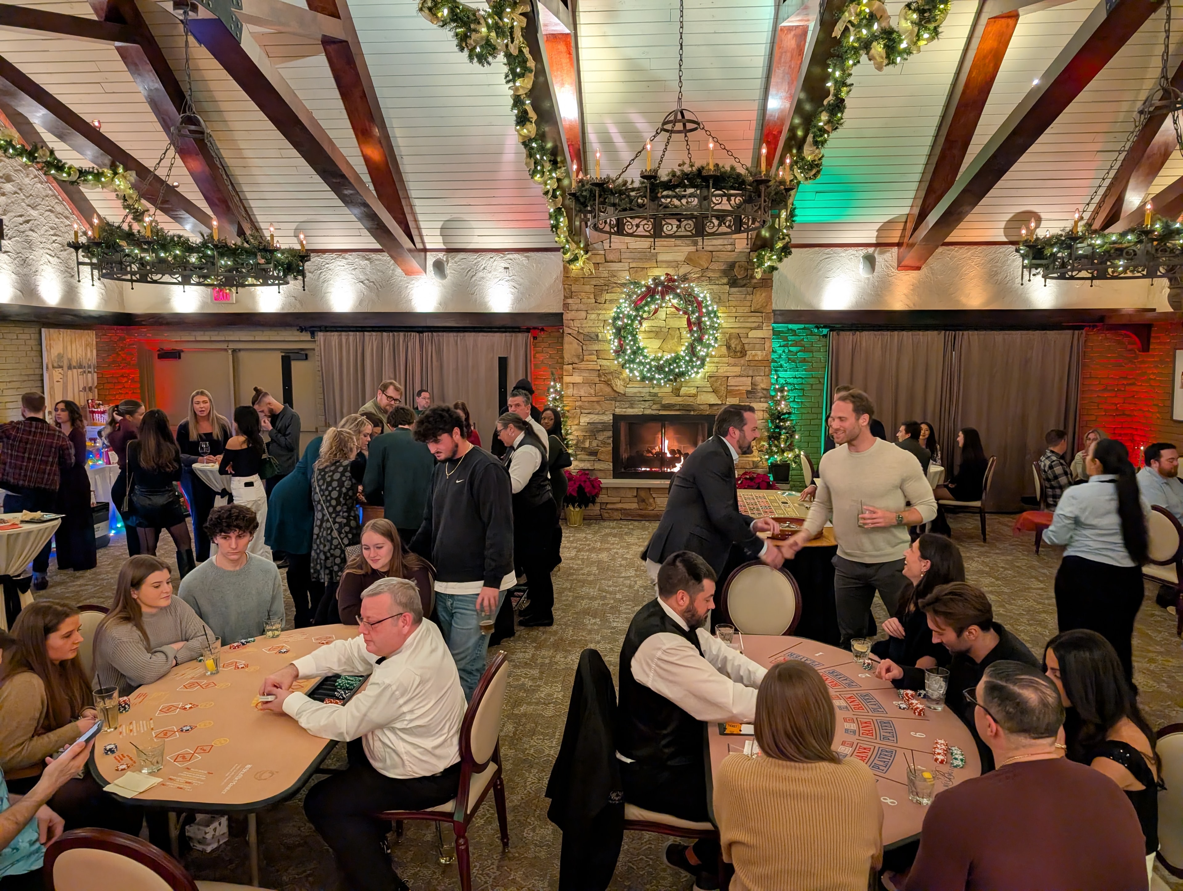 Wide-angle view of a full Casino Party USA event ballroom with fireplace and Christmas wreath in Detroit