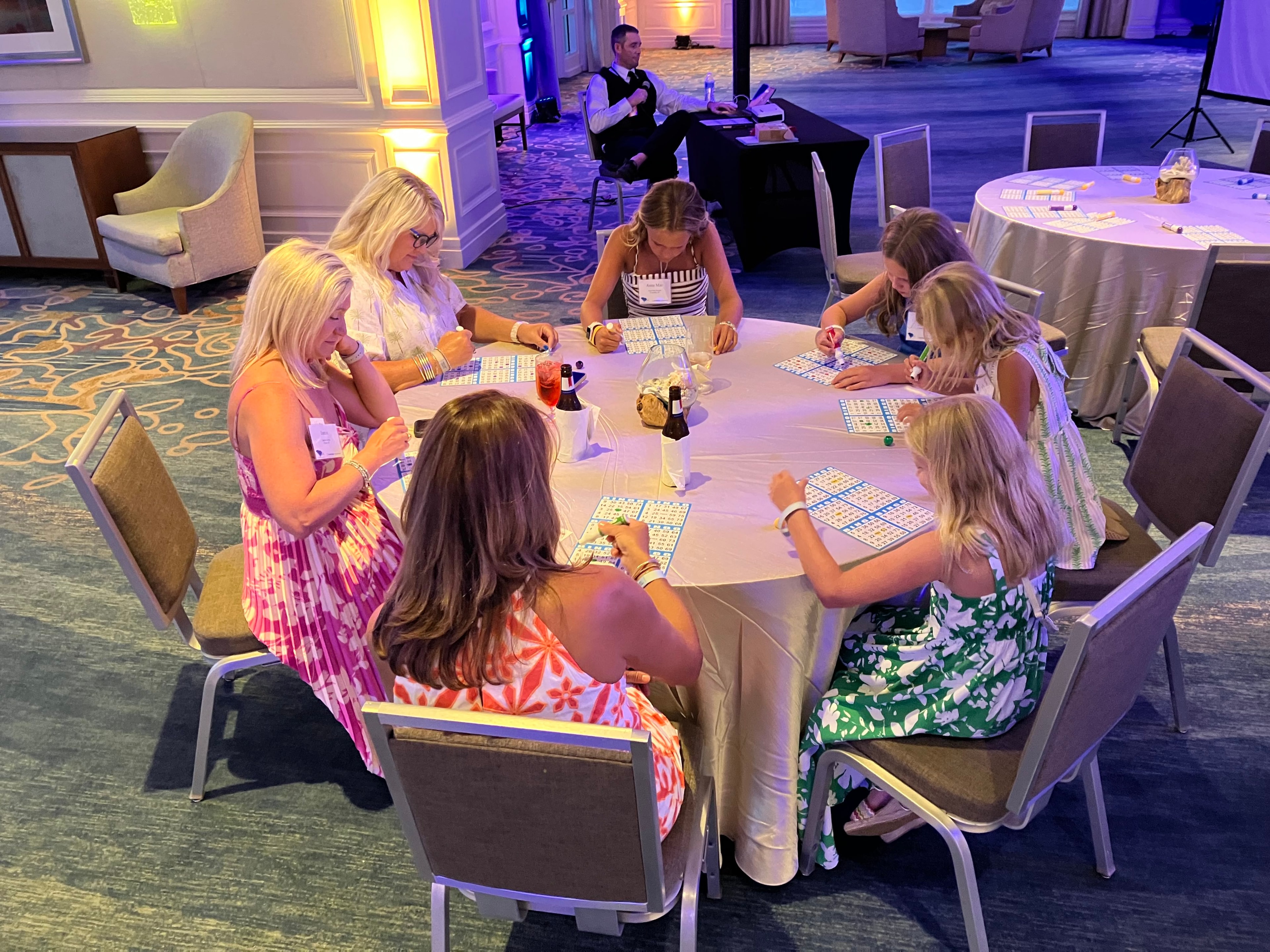 Guests playing bingo at round tables in a hotel ballroom at a Casino Party USA event