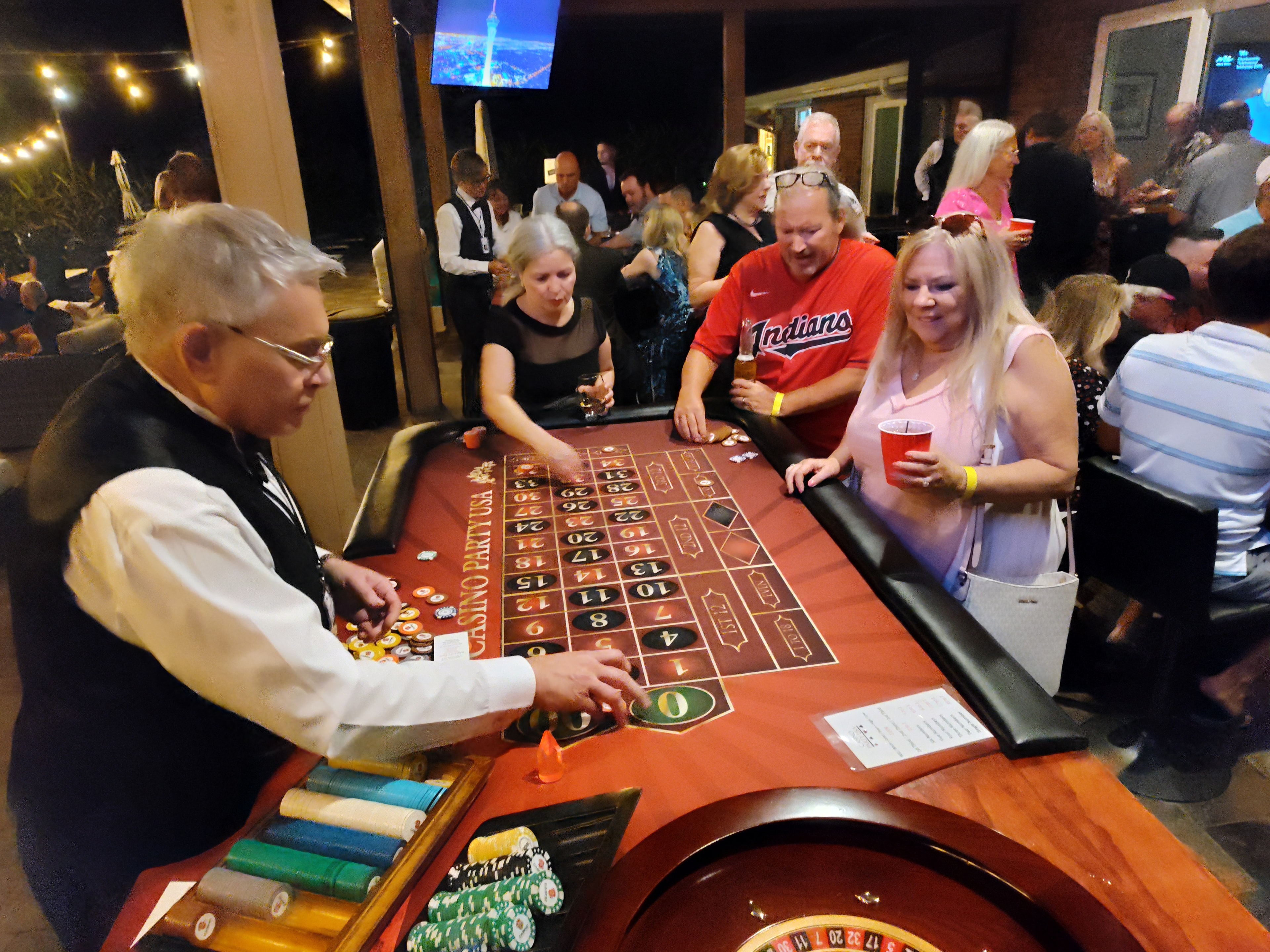 Guests around Casino Party USA roulette table at an outdoor casino event