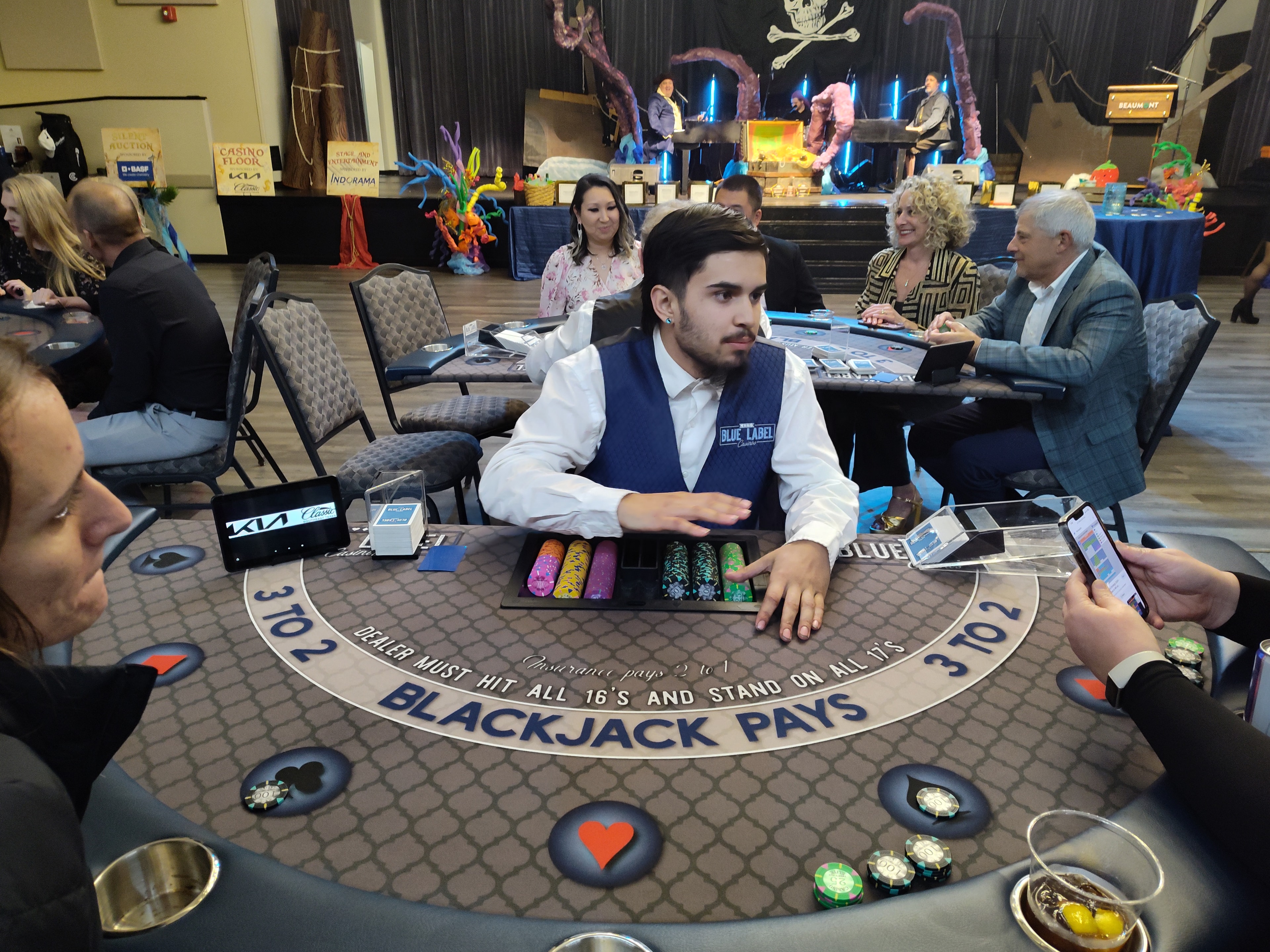 Blue Label Casinos dealer at a blackjack table with pirate stage backdrop at a Houston casino party event