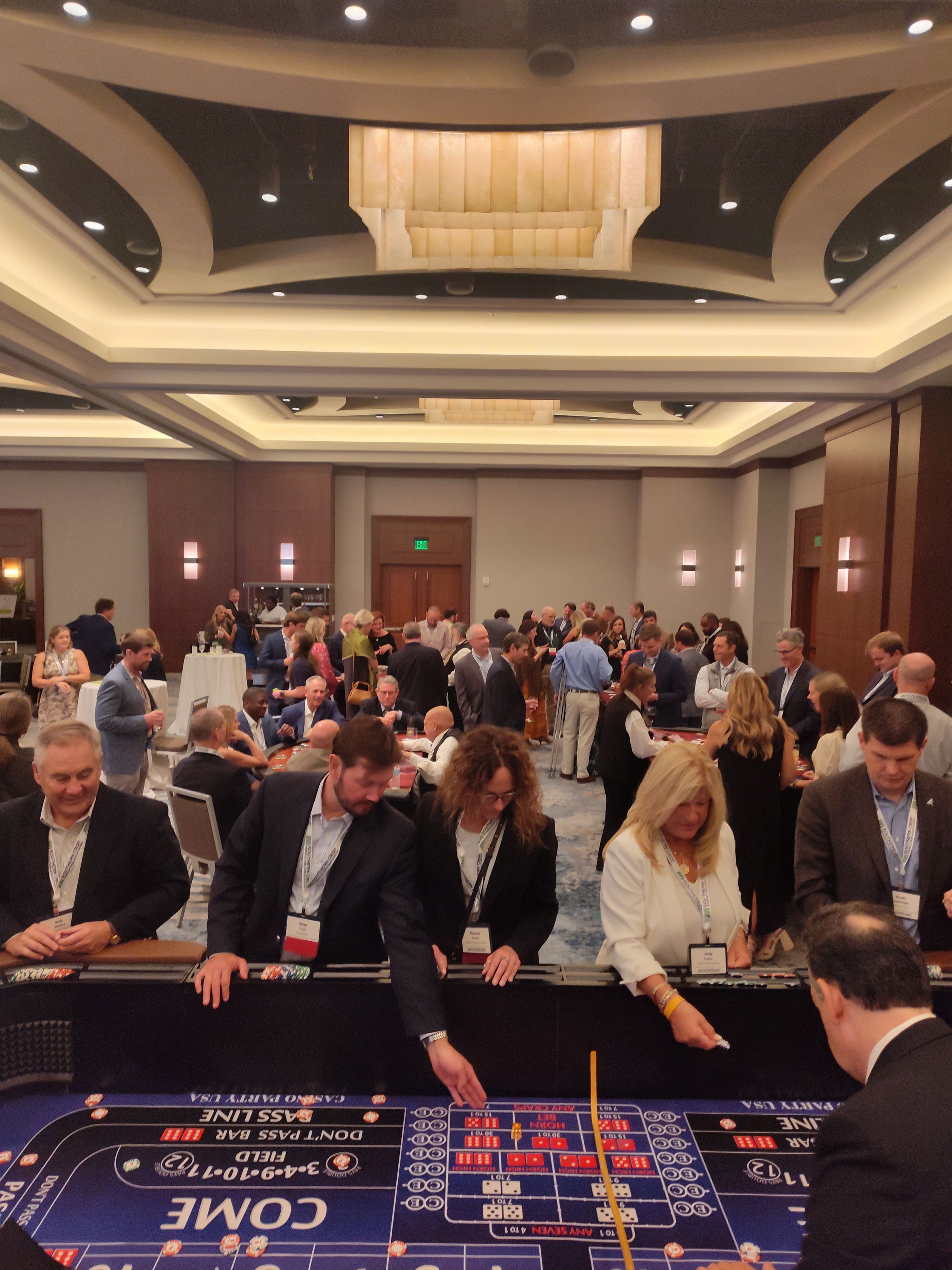 Massive crowd packed around a Casino Party USA blue craps table at a Jacksonville event