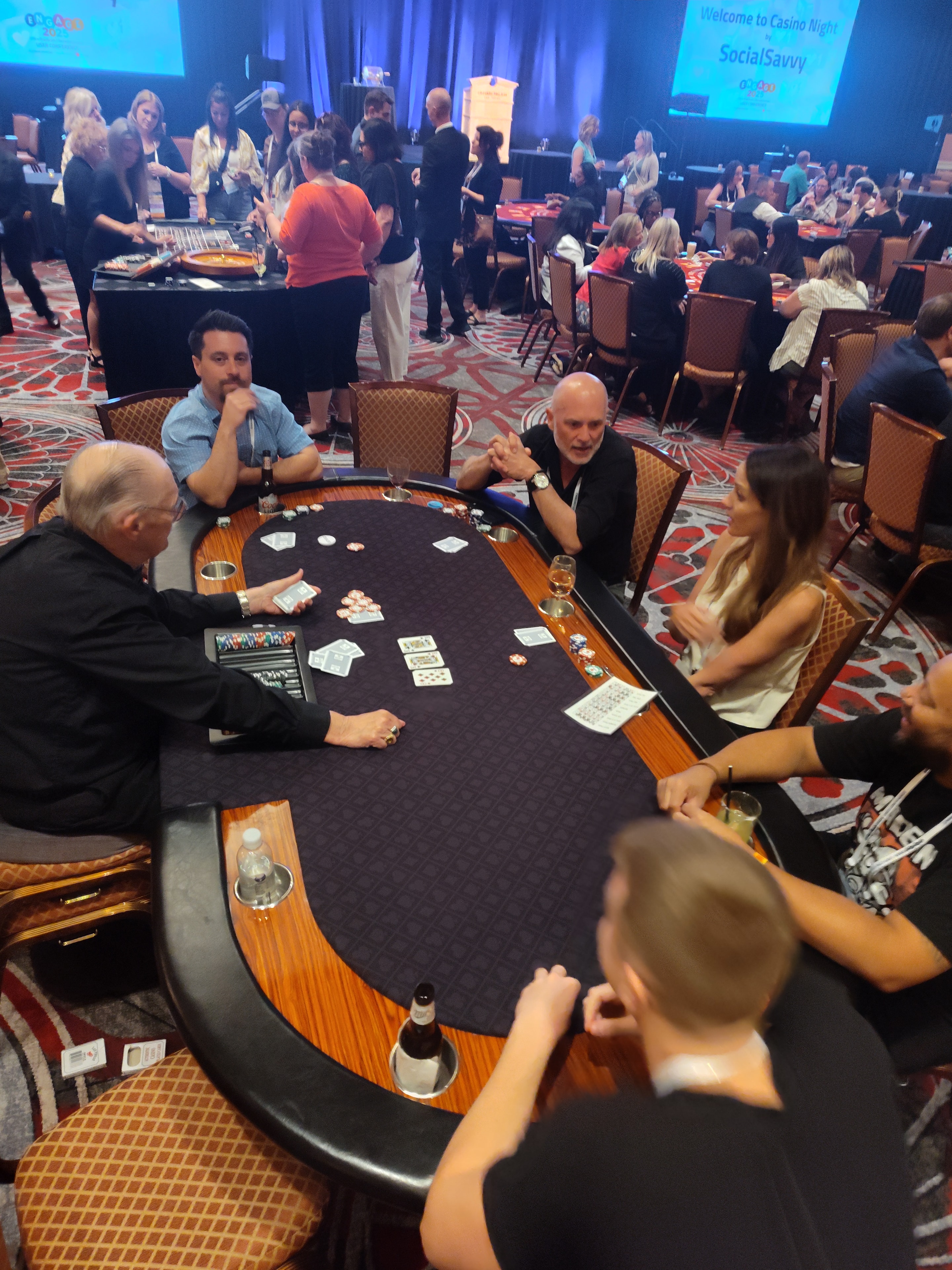 Wide-angle view of a packed Casino Party USA ballroom event in Las Vegas with the SocialSavvy Casino Night backdrop