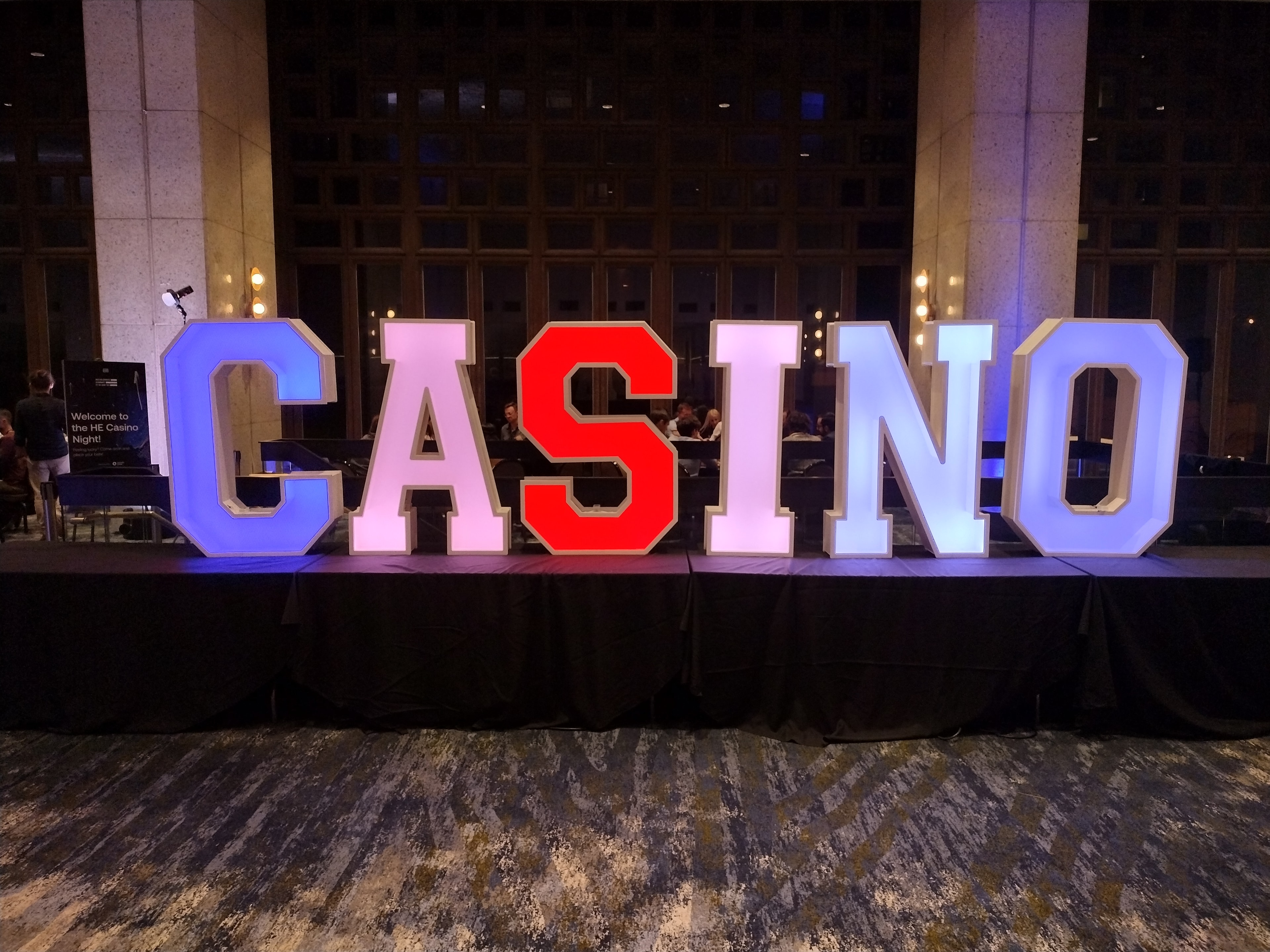 Giant LED CASINO marquee letters in red, blue, and white at HE Casino Night event