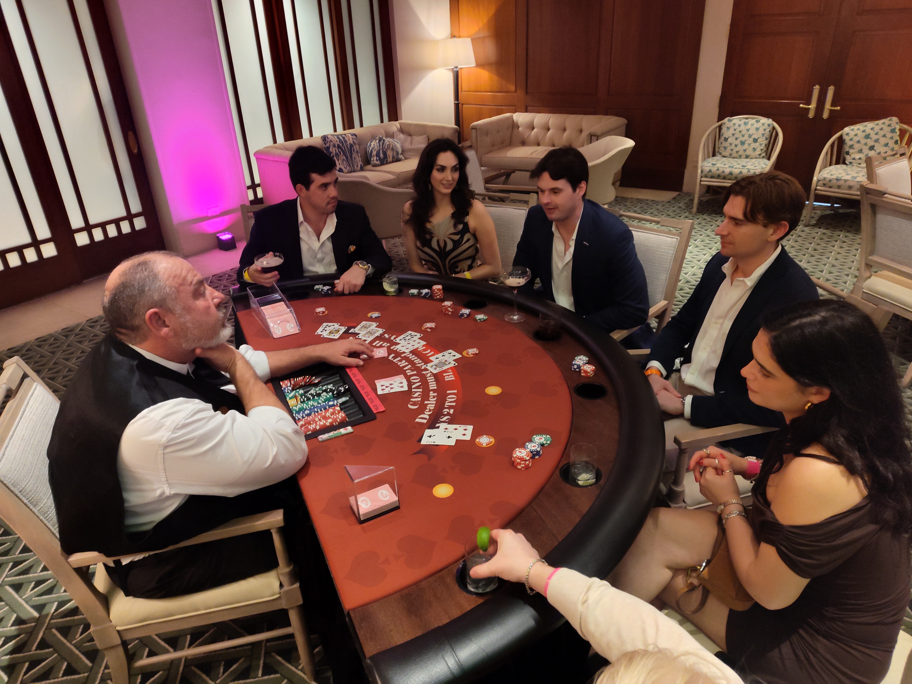 Guests seated at a Casino Party USA blackjack table in an upscale lounge setting in Miami