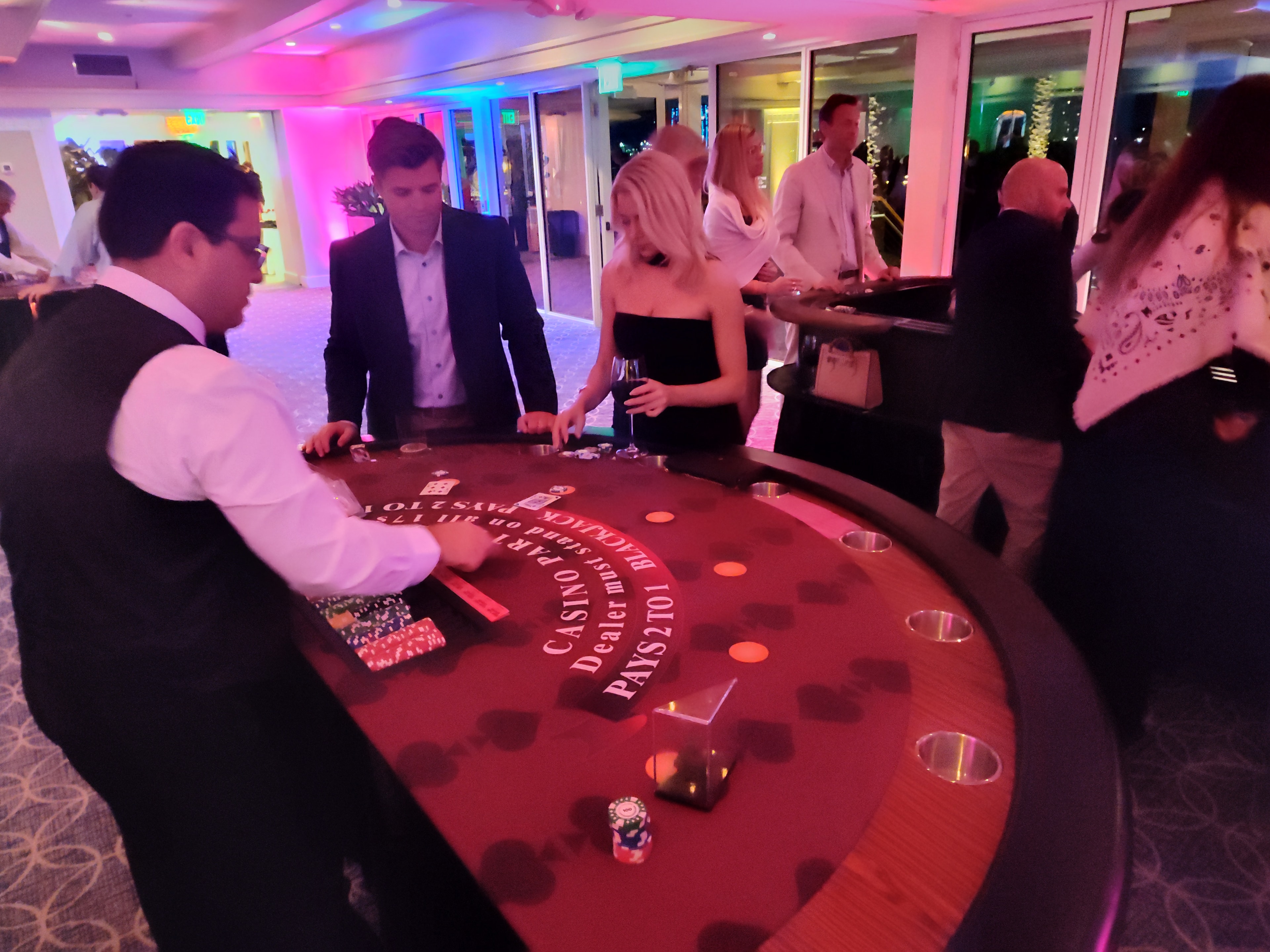 Dealer running a Casino Party USA blackjack table with guests in formal attire in Miami