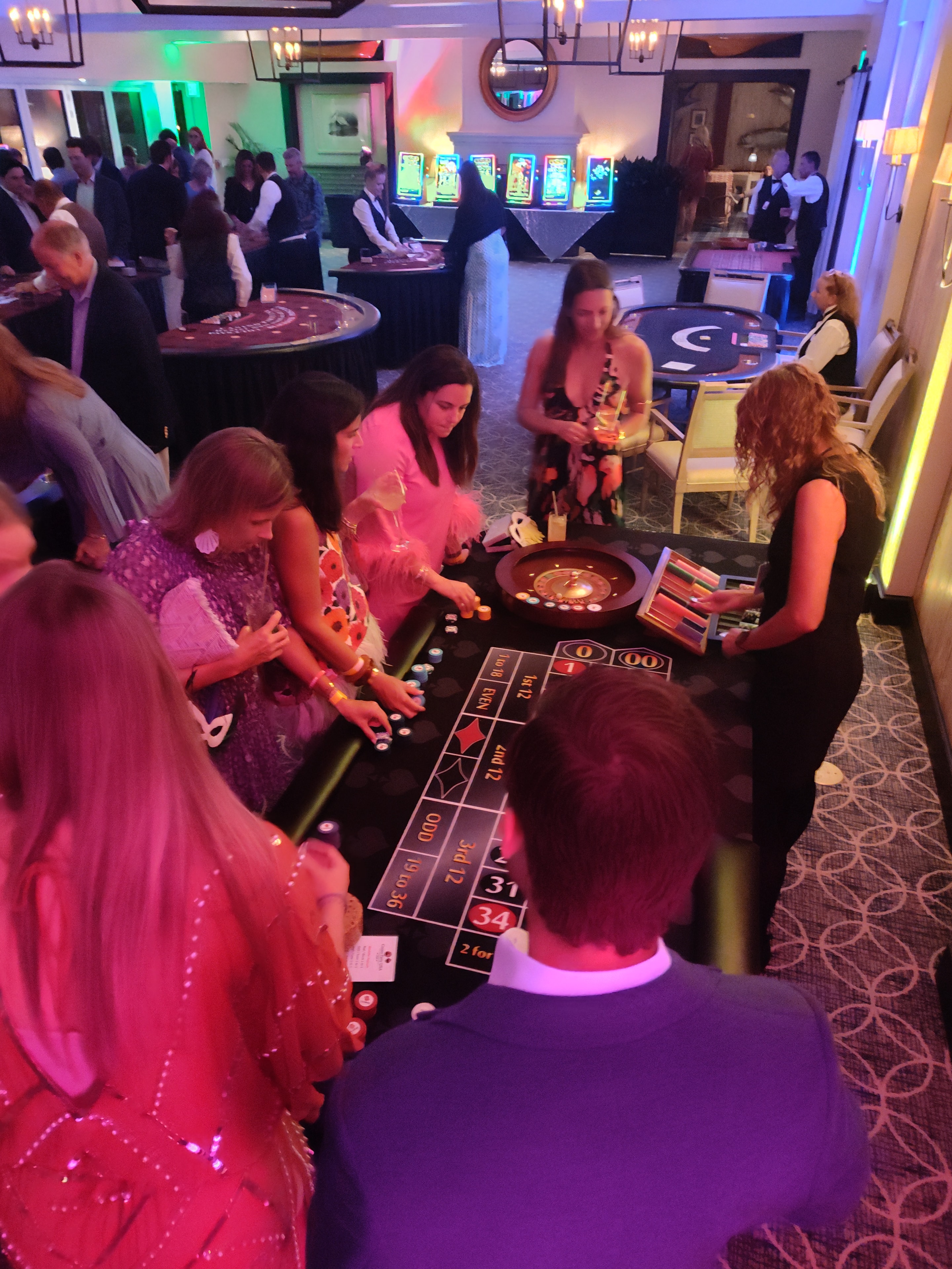 Guests in pink attire playing roulette at a Casino Party USA event in Miami