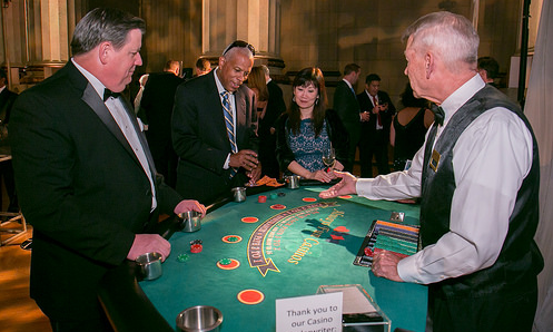 Dealer and guests at a blackjack table at a Northern Virginia Casino Party USA event