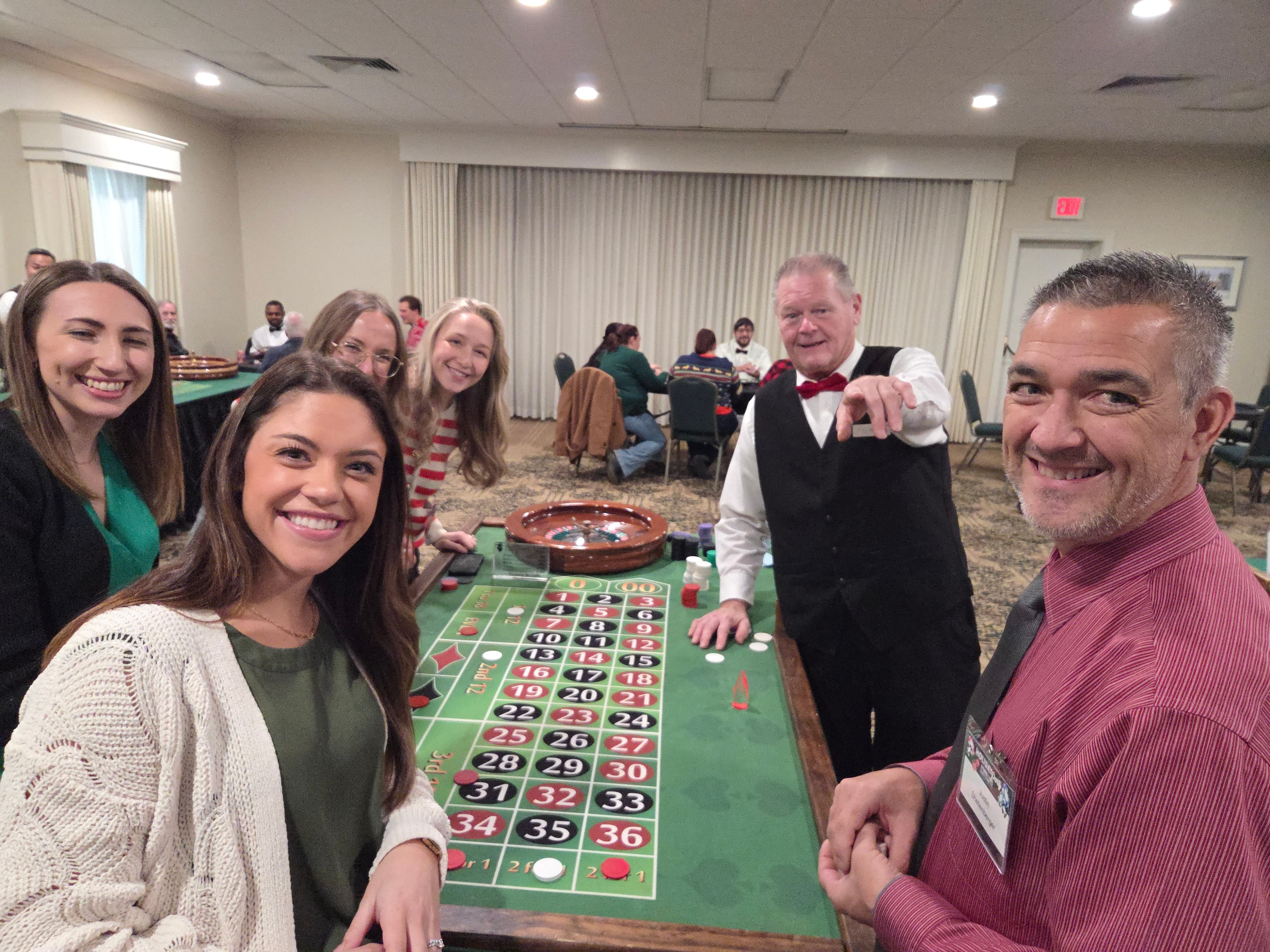 Guests smiling at a roulette table at a Casino Party USA Philadelphia holiday party