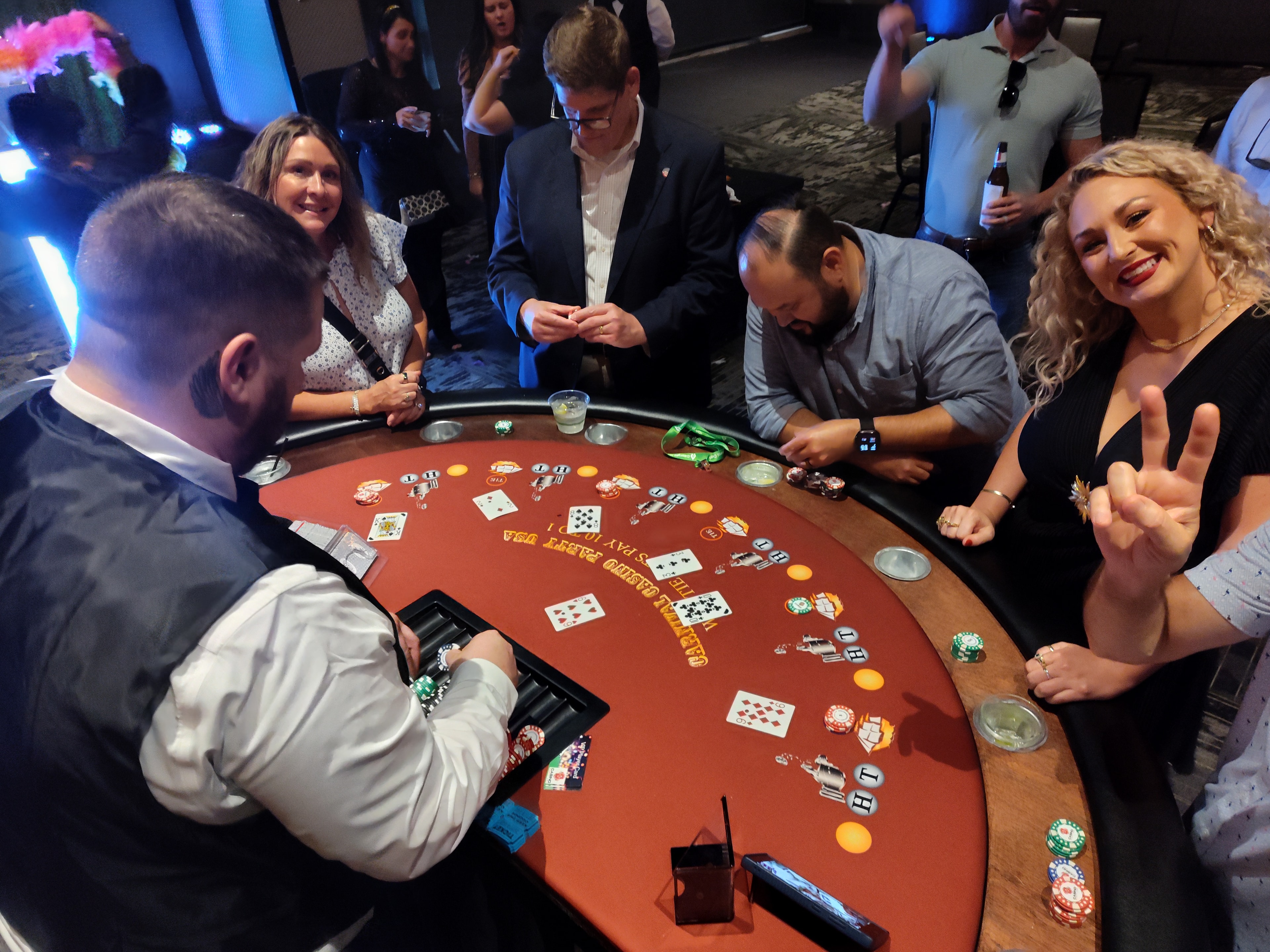 Smiling guests at a Casino Party USA red blackjack table at a Savannah corporate casino night