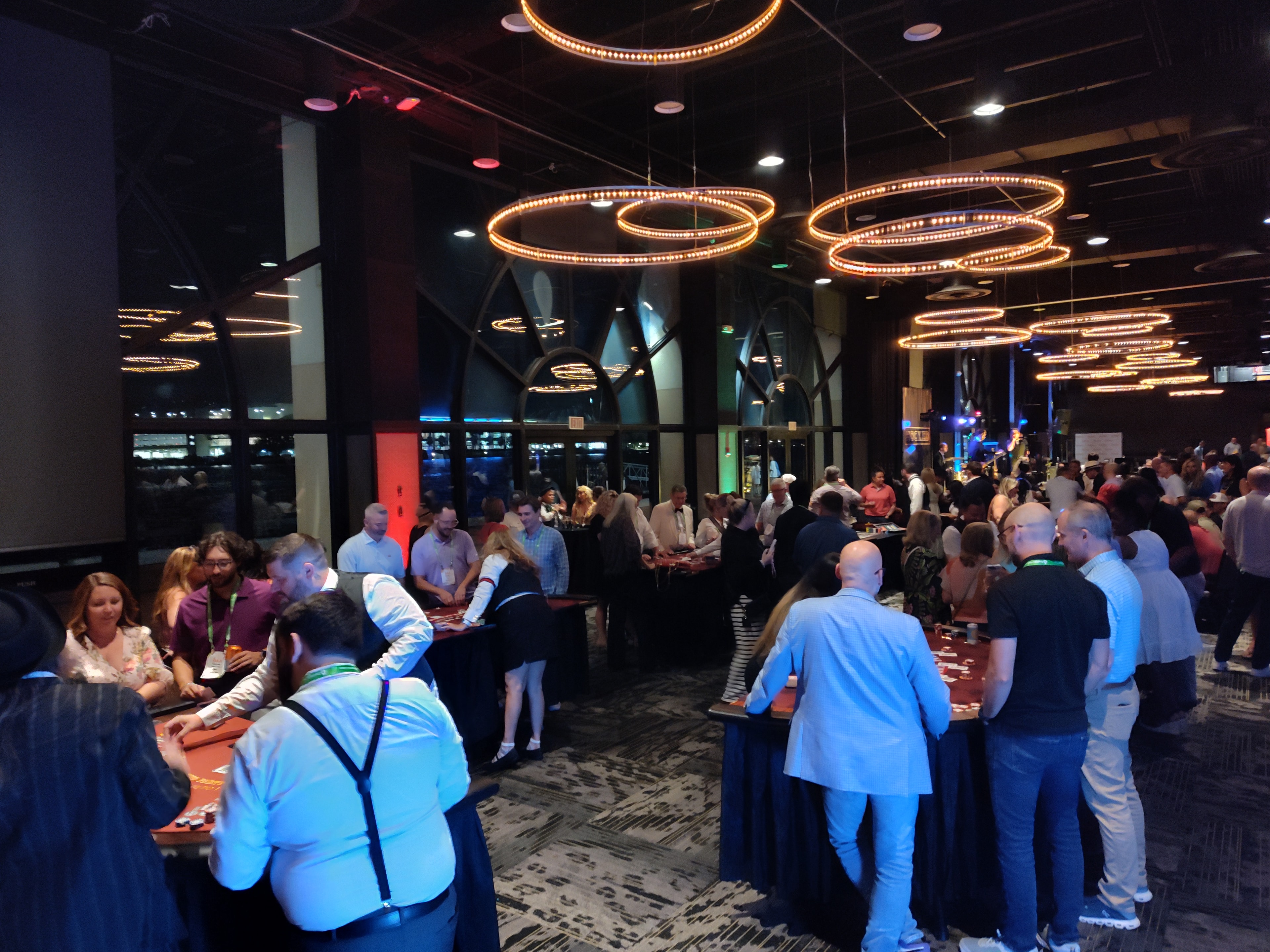 Wide-angle view of a packed Casino Party USA ballroom event with ring chandeliers in Savannah