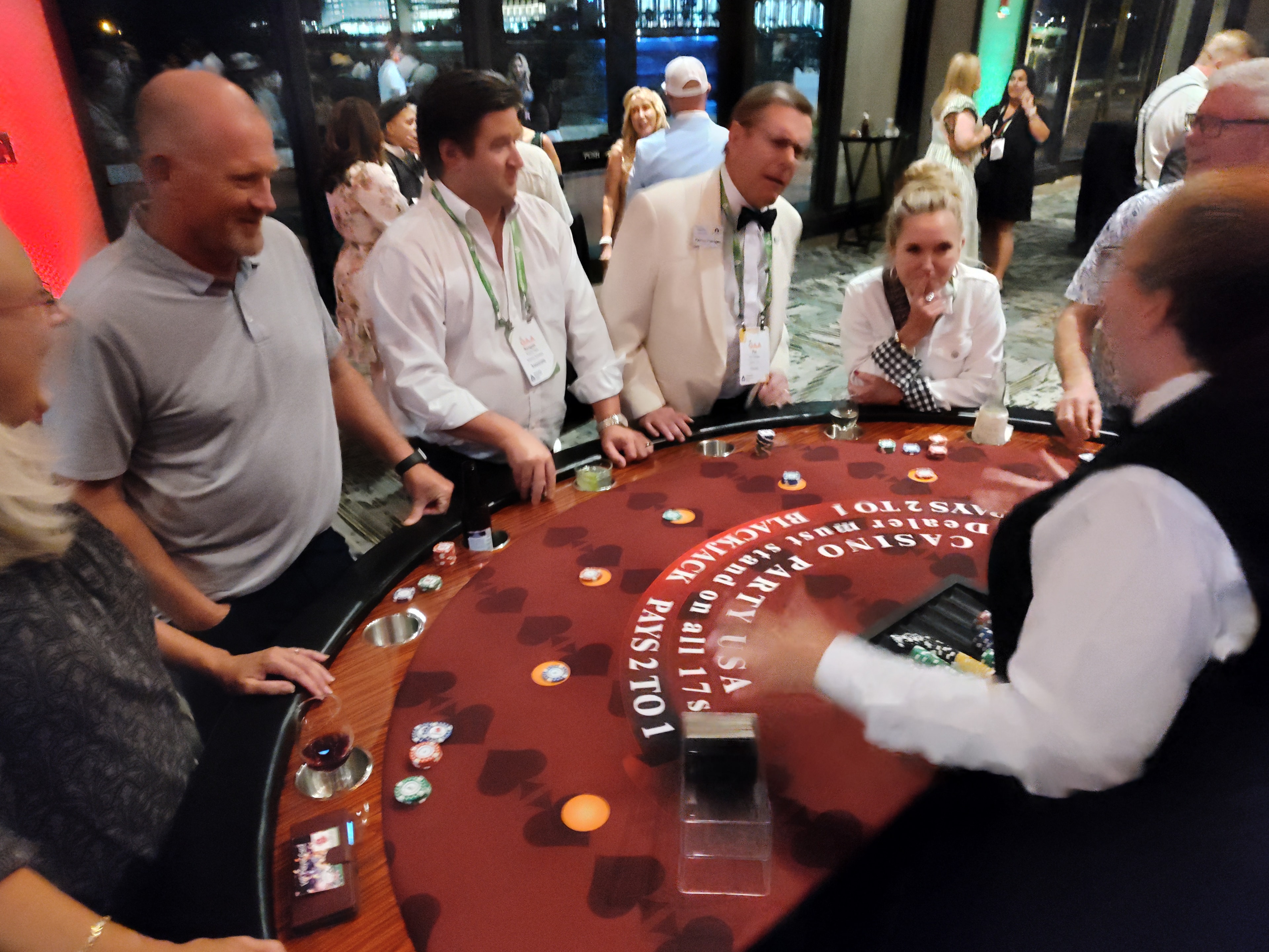 Guests in formal attire at a Casino Party USA branded blackjack table at a Savannah corporate event
