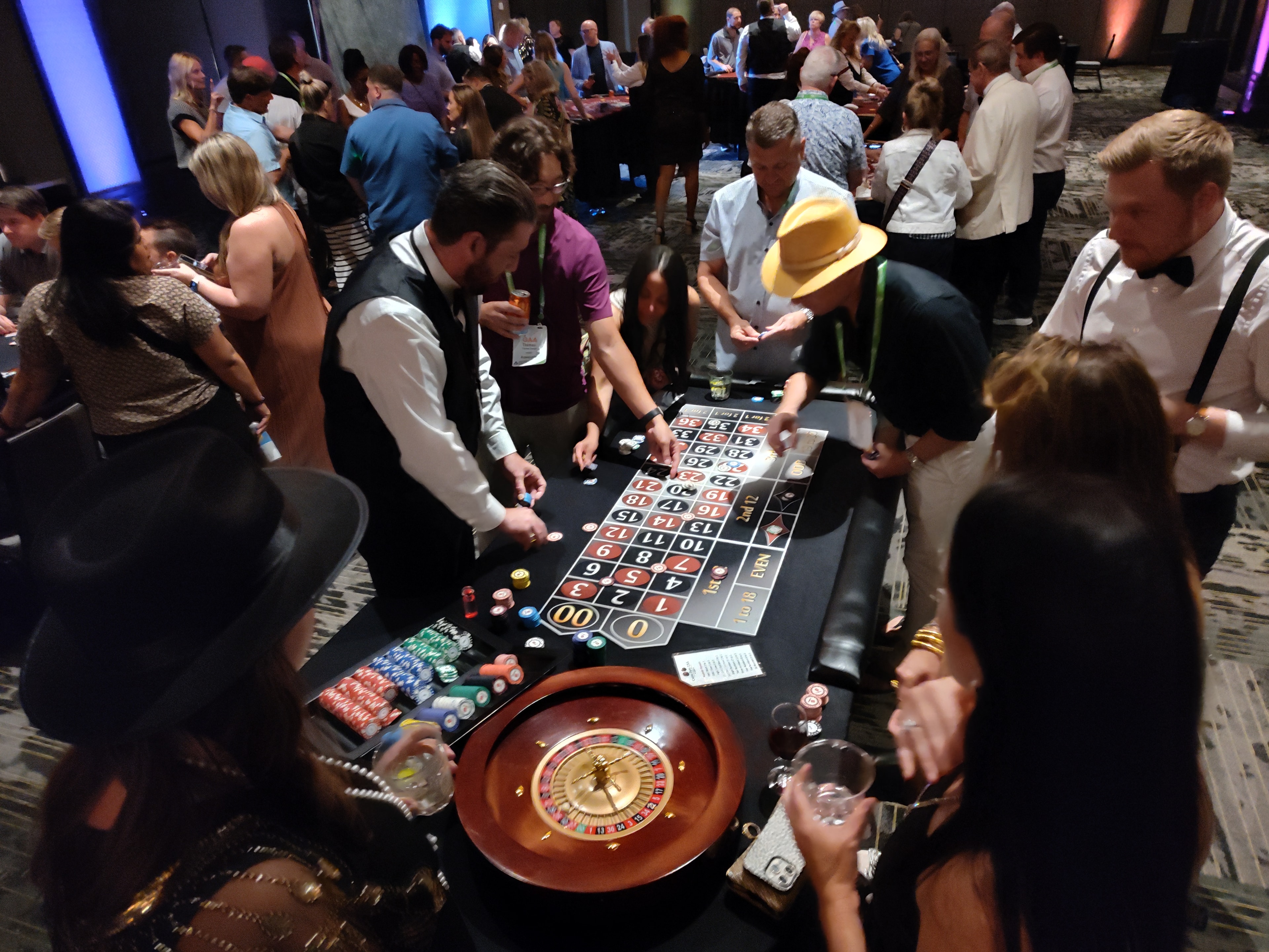 Guests and dealer at a Casino Party USA roulette table with a packed ballroom behind them in Savannah