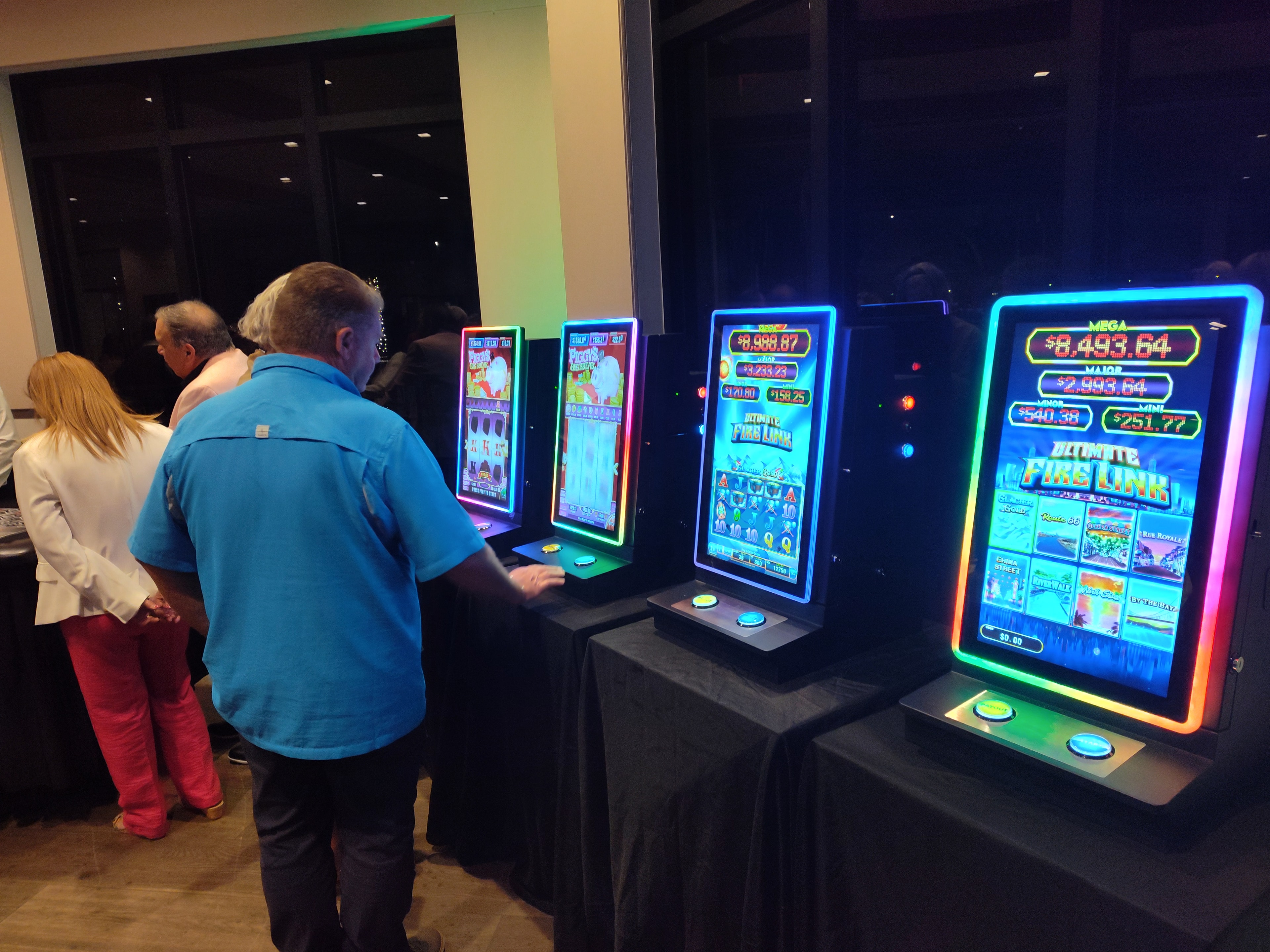 Guests playing neon-lit slot machines at a Casino Party USA event
