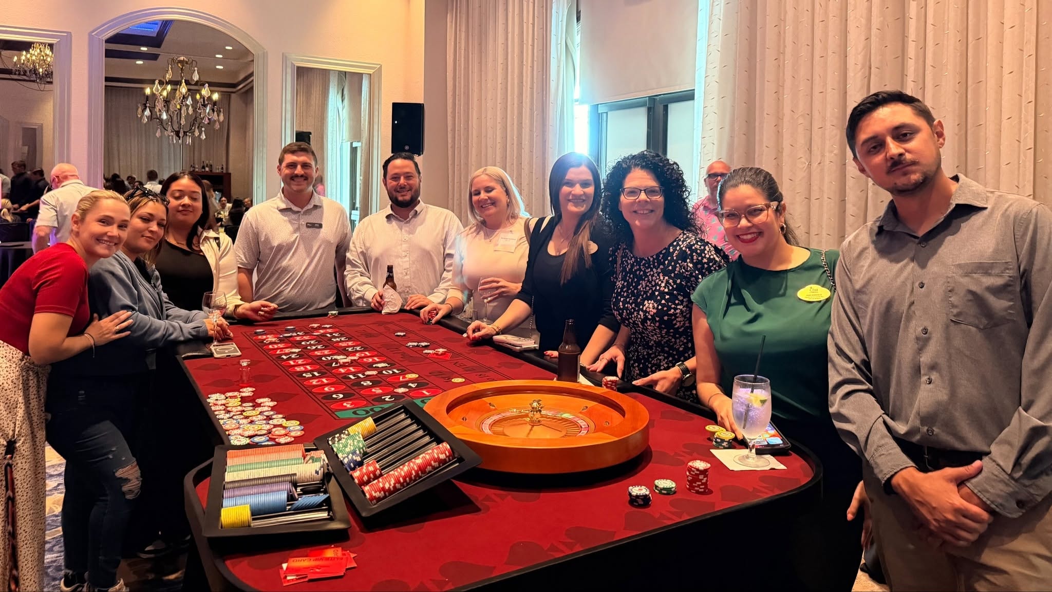 Group of guests posing at a roulette table at a Tampa Casino Party USA event